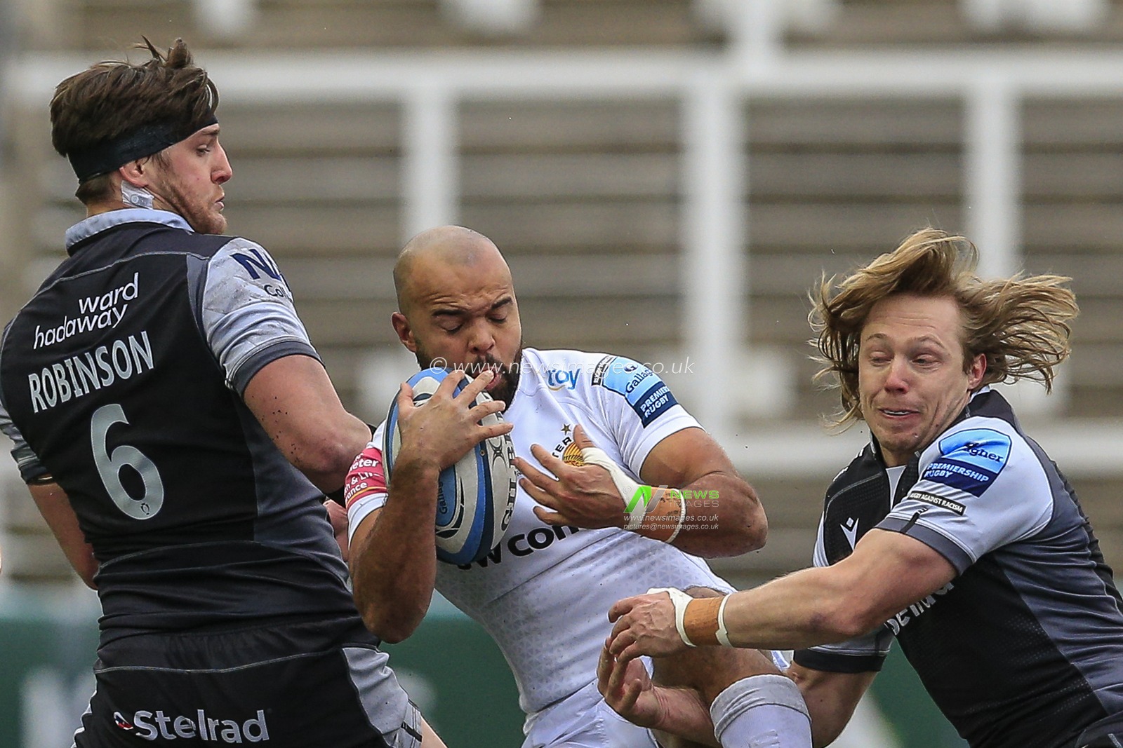 Joel Hodgson of Newcastle Falcons, Tom O'Flaherty of Exeter Chiefs and Sean Robinson of Newcastle Falcons battle for the ball