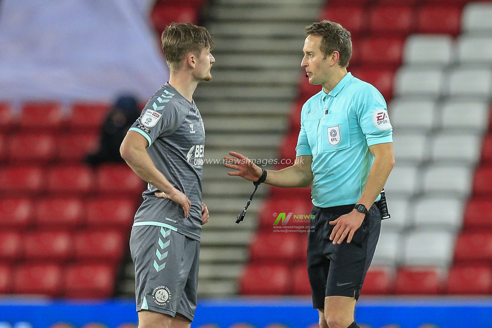 Callum Connolly #4 of Fleetwood Town talks with referee James Bell