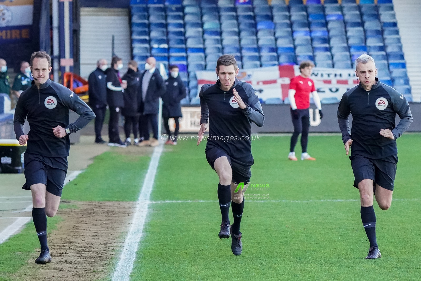 Referee Matt Donohue warms up with Assistant Referees Mark Russell and George Byrne
