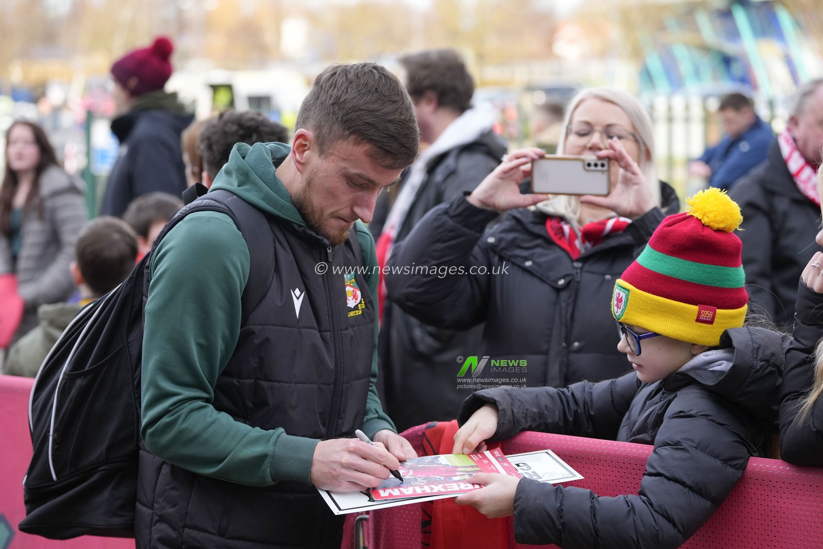 Luke Young #8 of Wrexham signs an autograph for a young fan before the Emirates FA Cup fourth round match Wrexham vs Sheffield United at The Racecourse Ground, Wrexham, United Kingdom, 29th January 2023

(Photo by Steve Flynn/News Images)