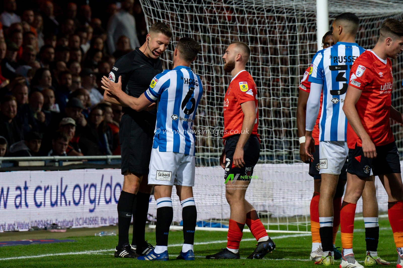 Referee Robert Jones has a word with Jonathan Hogg #6 of Huddersfield Town and Allan Campbell #22 of Luton Town