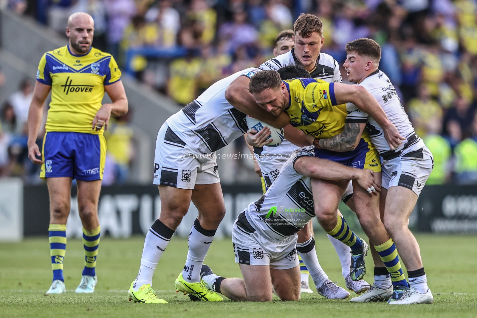 Ben Currie of Warrington Wolves is tackled during the Betfred Super League round 16 match Warrington Wolves vs Hull FC at Halliwell Jones Stadium, Warrington, United Kingdom, 28th June 2025

(Photo by Alfie Cosgrove/News Images)