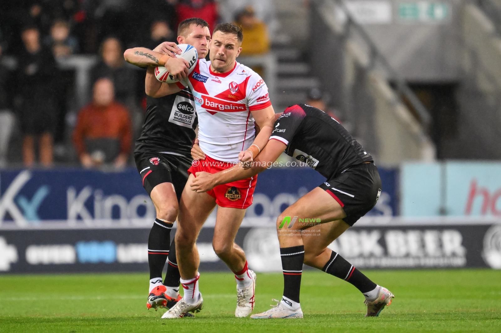 Matty Lees of St. Helens is tackled by Marc Sneyd of Salford Red Devils and Sam Stone of Salford Red Devils during the Betfred Super League Round 21 match St Helens vs Salford Red Devils at Totally Wicked Stadium, St Helens, United Kingdom, 8th August 2024

(Photo by Craig Thomas/News Images)