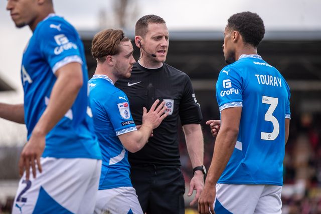 Referee Simon Mather speaks to Stockport County players after awarding Wrexham a first half penalty during the Sky Bet League 1 match Wrexham vs Stockport County at SToK Cae Ras, Wrexham, United Kingdom, 22nd March 2025

(Photo by Nik Mesney/News Images)