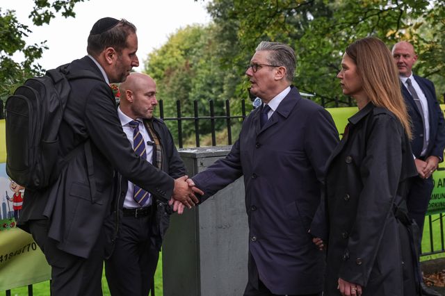 Victoria, Lady Starmer holds her husband Sir Keir Starmer, Prime Minister of the United Kingdom of Great Britain and Northern Ireland’s hand as he shakes hands with a member of the local community during the Manchester synagogue terror attack day 2 at Heaton Park Shul, Manchester, United Kingdom, 3rd October 2025

(Photo by Mark Cosgrove/News Images)