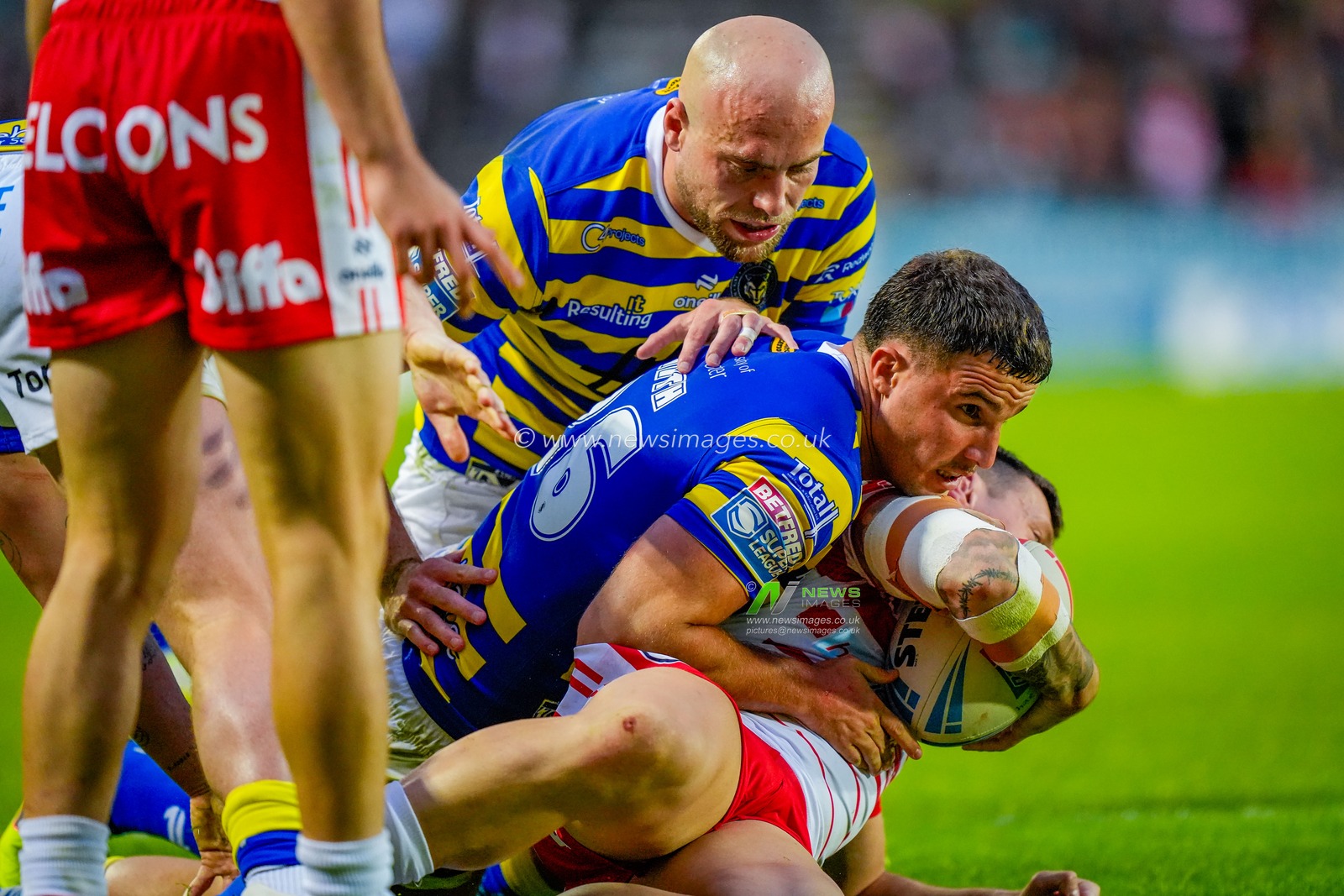 David Klemmer of St Helens R.F.C. is tackled by Josh Smith of Warrington Wolves and James Harrison of Warrington Wolves during the Betfred Super League round 14 match St Helens vs Warrington Wolves at The BrewDog Stadium, St Helens, United Kingdom on 11 June 2026

(Photo by Maynard Manyowa/News Images)