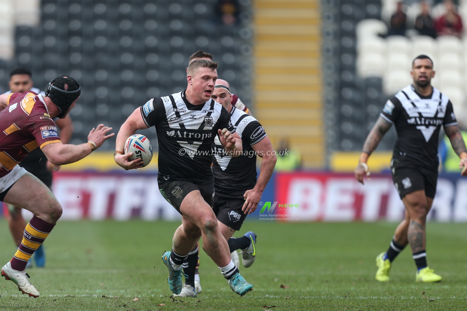 Jack Brown (20) of Hull FC gets through the Huddersfield defence