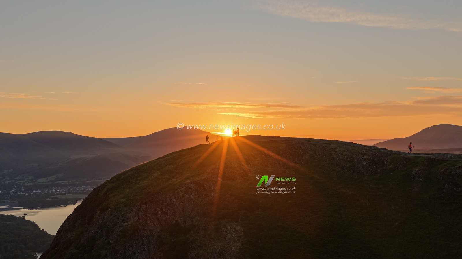Photographers take pictures as the sun rises from the summit of Catbells overlooking Derwent Water and the town of Keswick In the Lake District, Cumbria, United Kingdom, 19th June 2025

(Photo by Mark Cosgrove/News Images)