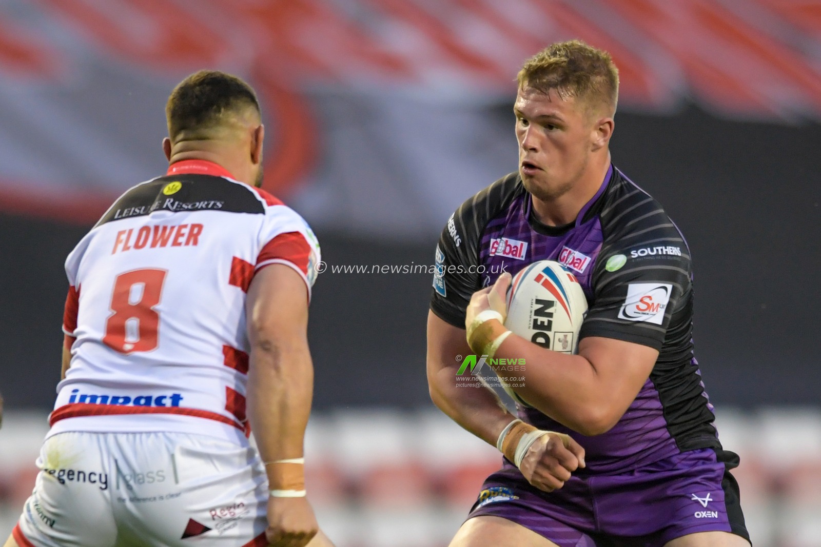 Tom Holroyd (18) of Leeds Rhinos looks for a way past Ben Flower (8) of Leigh Centurions