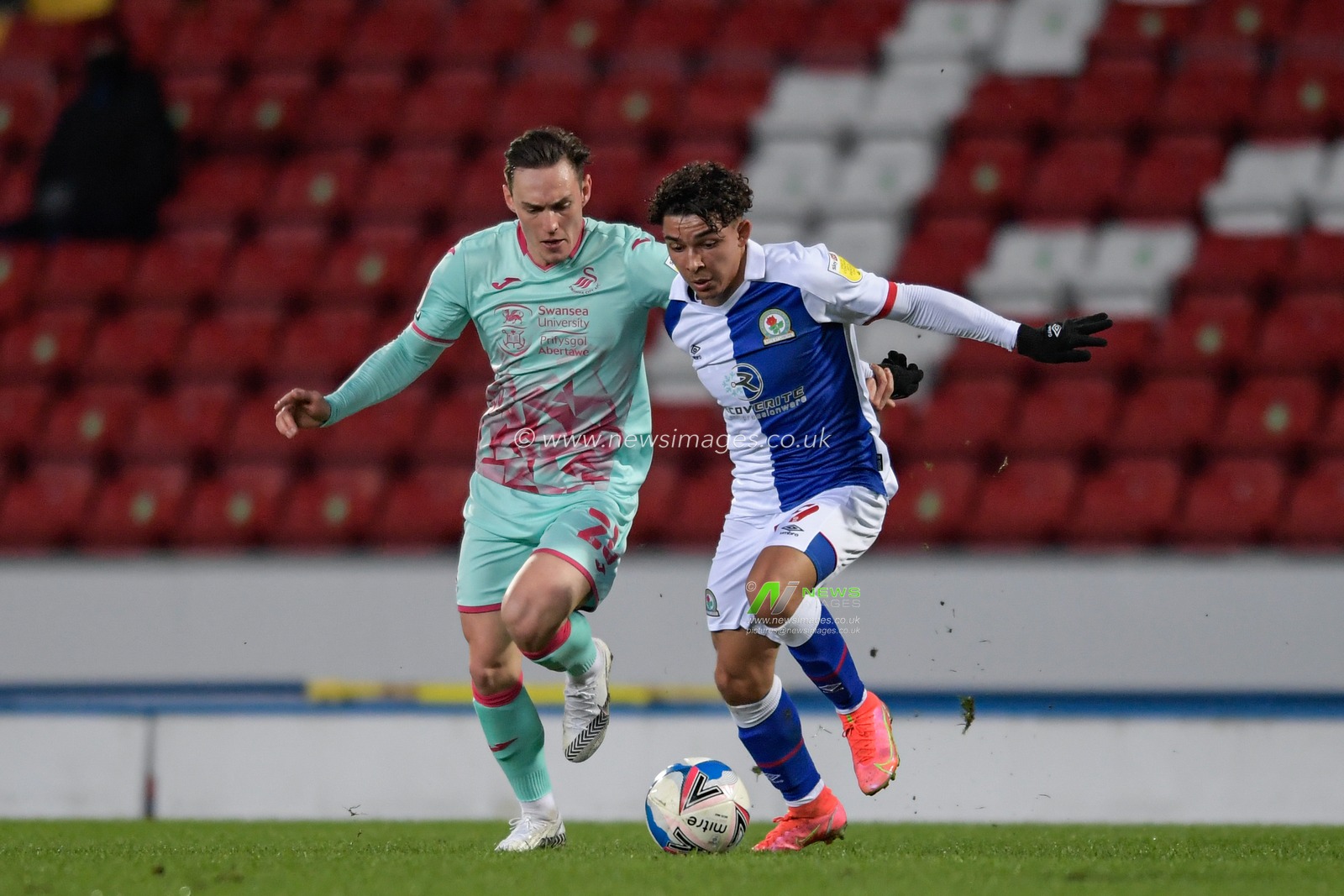 Connor Roberts #23 of Swansea City challenges Tyrhys Dolan #39 of Blackburn Rovers for the ball
