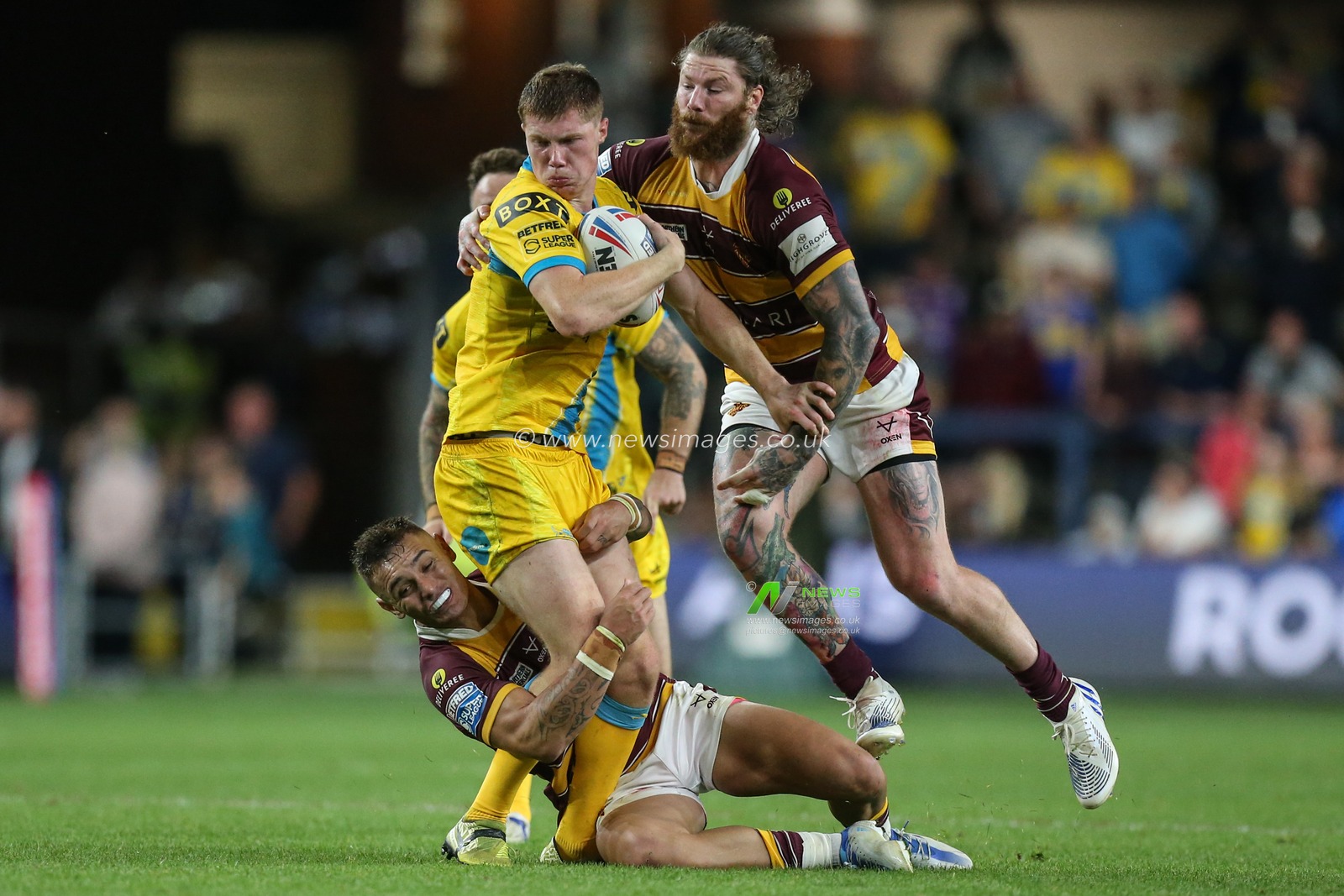 Morgan Gannon #21 of Leeds Rhinos is tackled by Danny Levi #9 of Huddersfield Giants