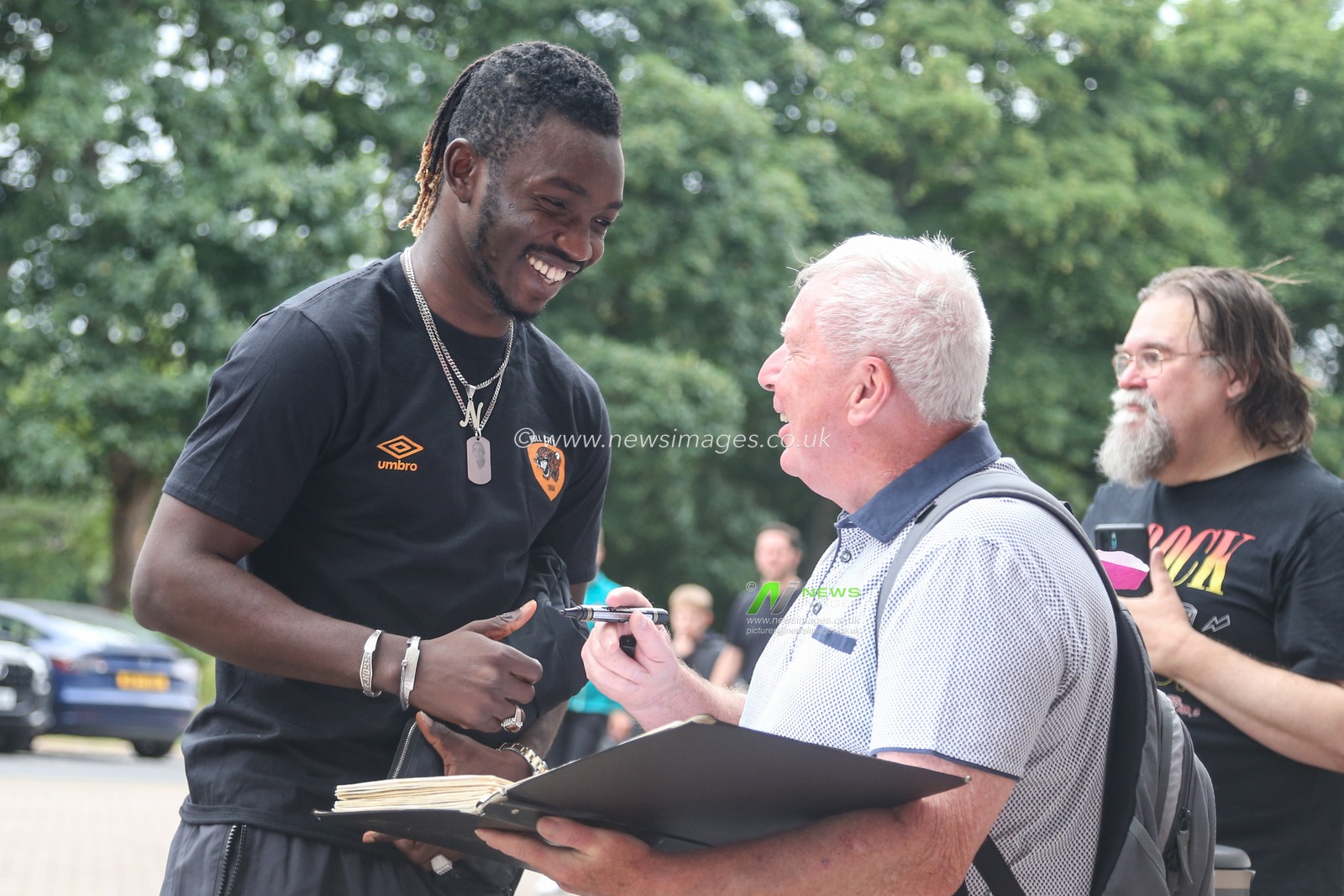 Adama Traore of Hull City arrives at the MKM Stadium and signs an autograph for a fan