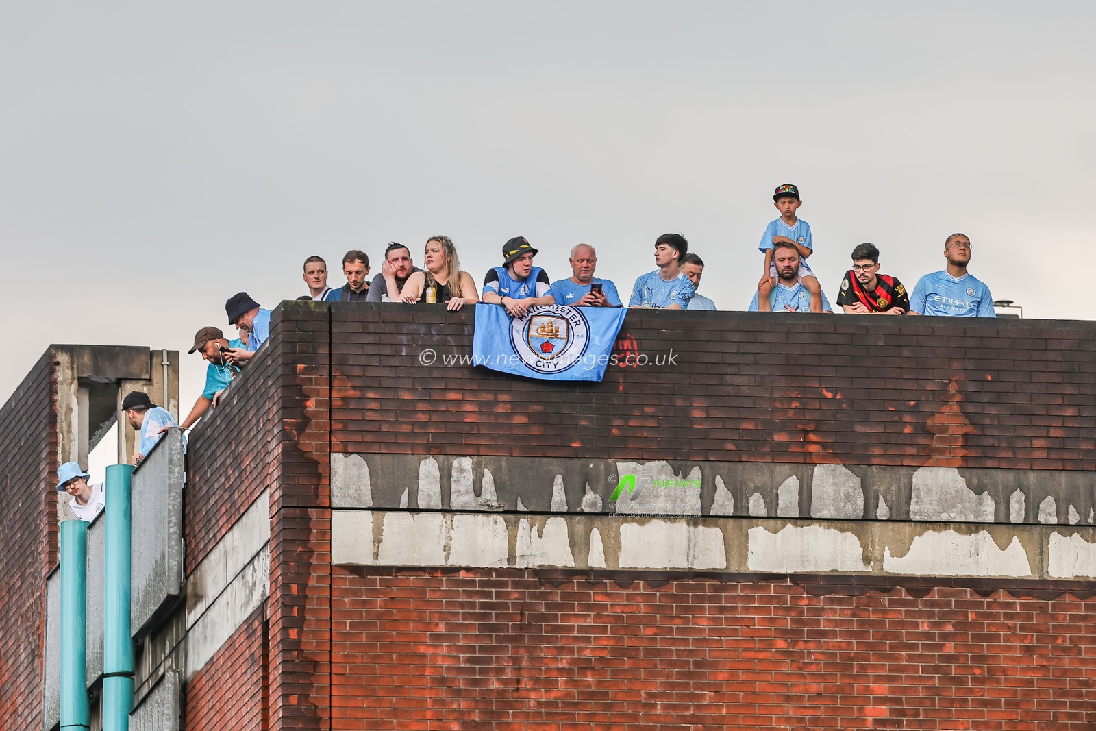 Fans take up roof top vantage point during Manchester City's Treble victory parade at St Peterâ€™s Square, Manchester, United Kingdom, 12th June 2023

(Photo by Mark Cosgrove/News Images)