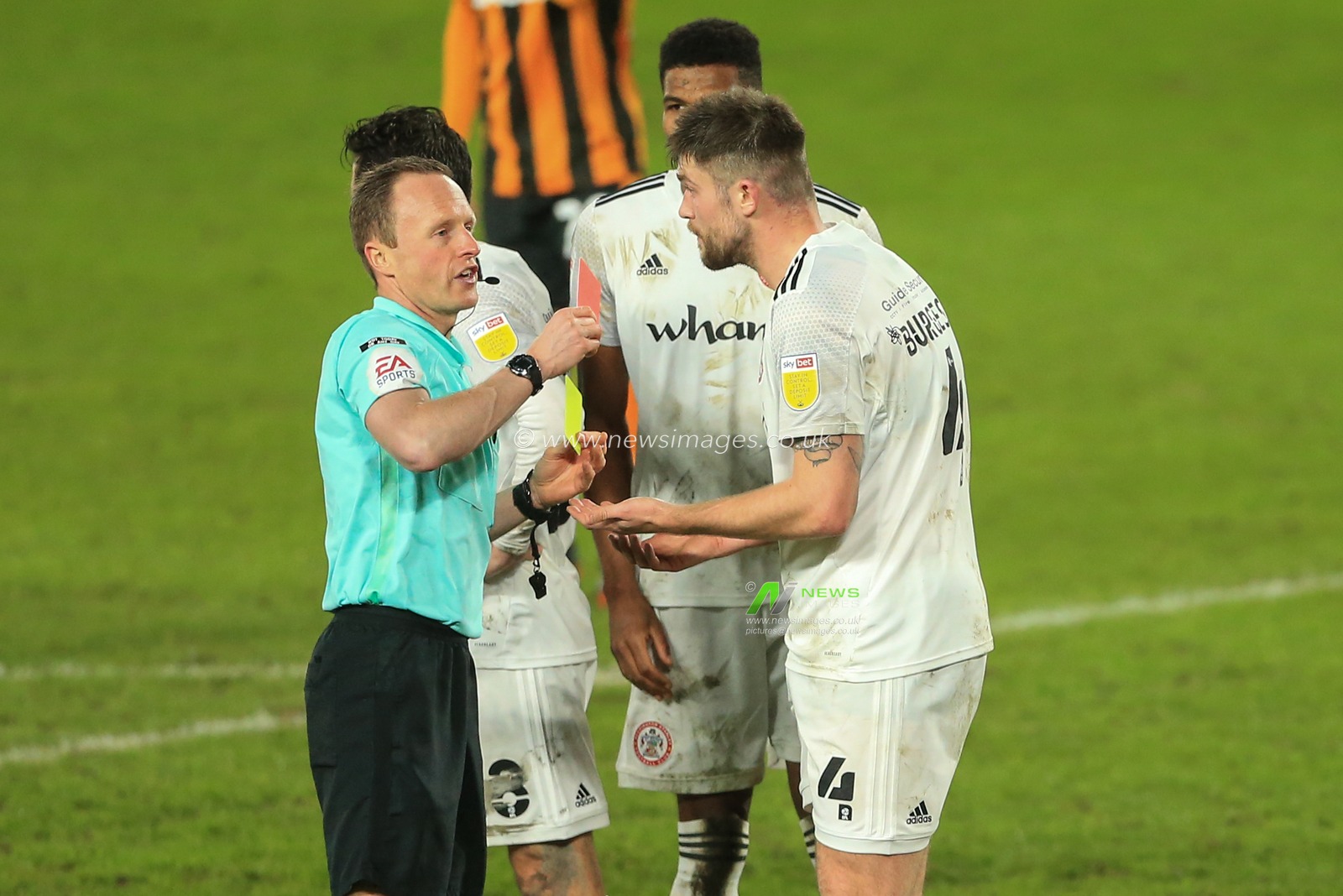 Referee David Rock gives Cameron Burgess #4 of Accrington Stanley a red card after a second yellow card