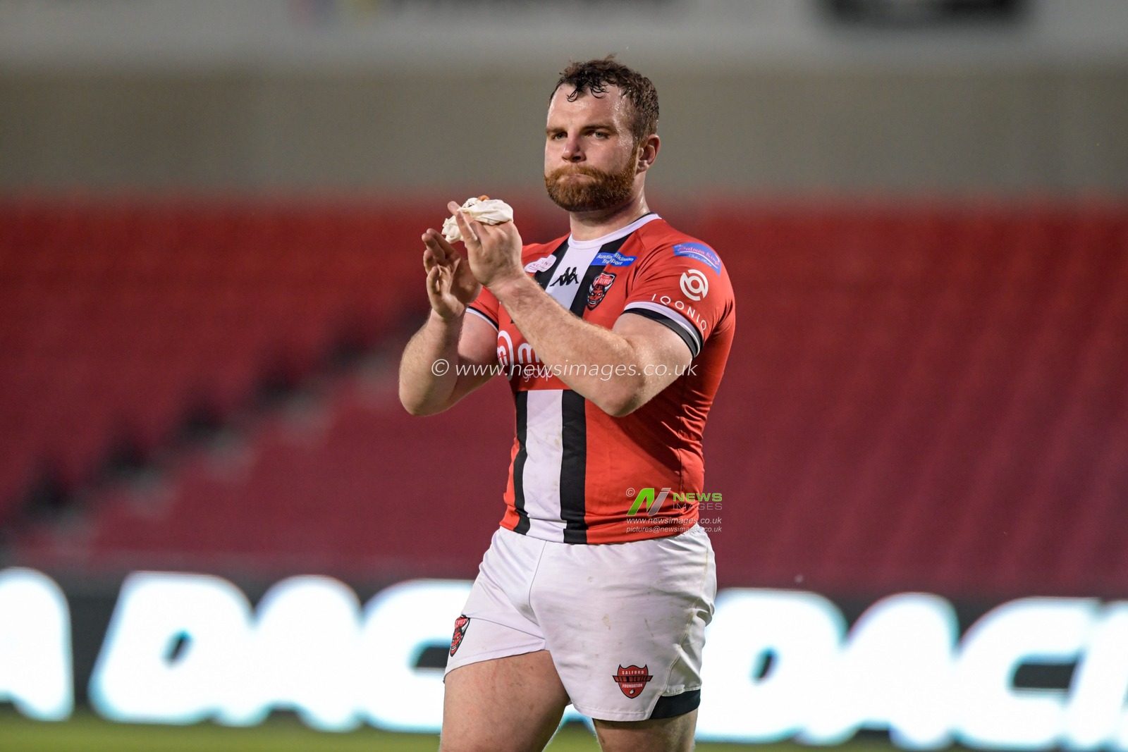 Greg Burke (16) of Salford Red Devils applauds the home supporters at the end of the game