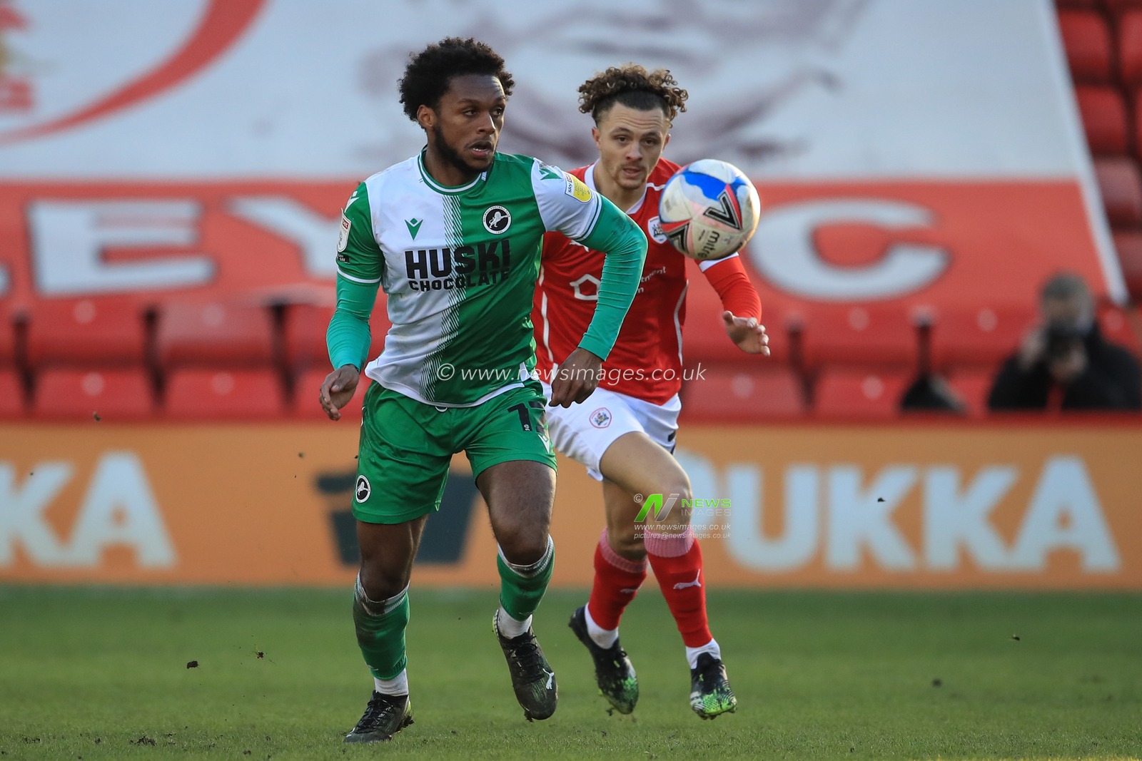 Mahlon Romeo #12 of Millwall breaks with the ball as Jordan Williams #2 of Barnsley gives chase