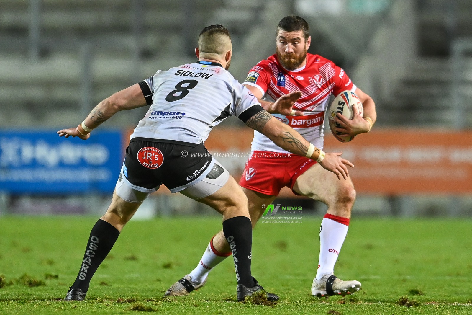 Kyle Amor (18) of St Helens takes on Adam Sidlow (8) of Leigh Centurions