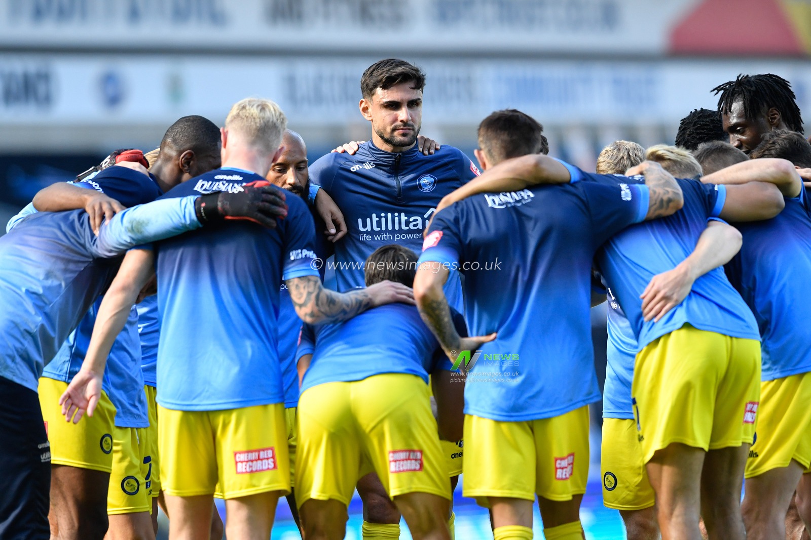 The Wycombe Wanderers players form a huddle before the game