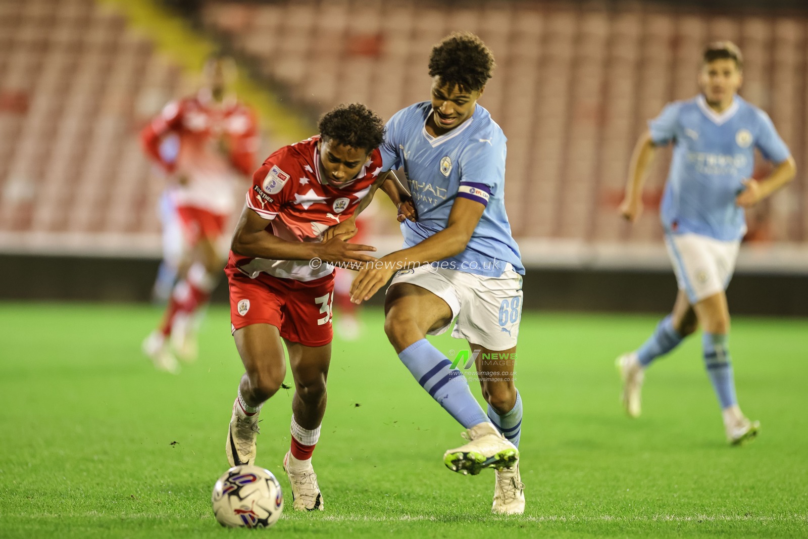 Theo Chapman #38 of Barnsley holds off Max Alleyne #68 of Manchester City U21 during the EFL Trophy match Barnsley vs Manchester City U21 at Oakwell, Barnsley, United Kingdom, 26th September 2023

(Photo by Mark Cosgrove/News Images)