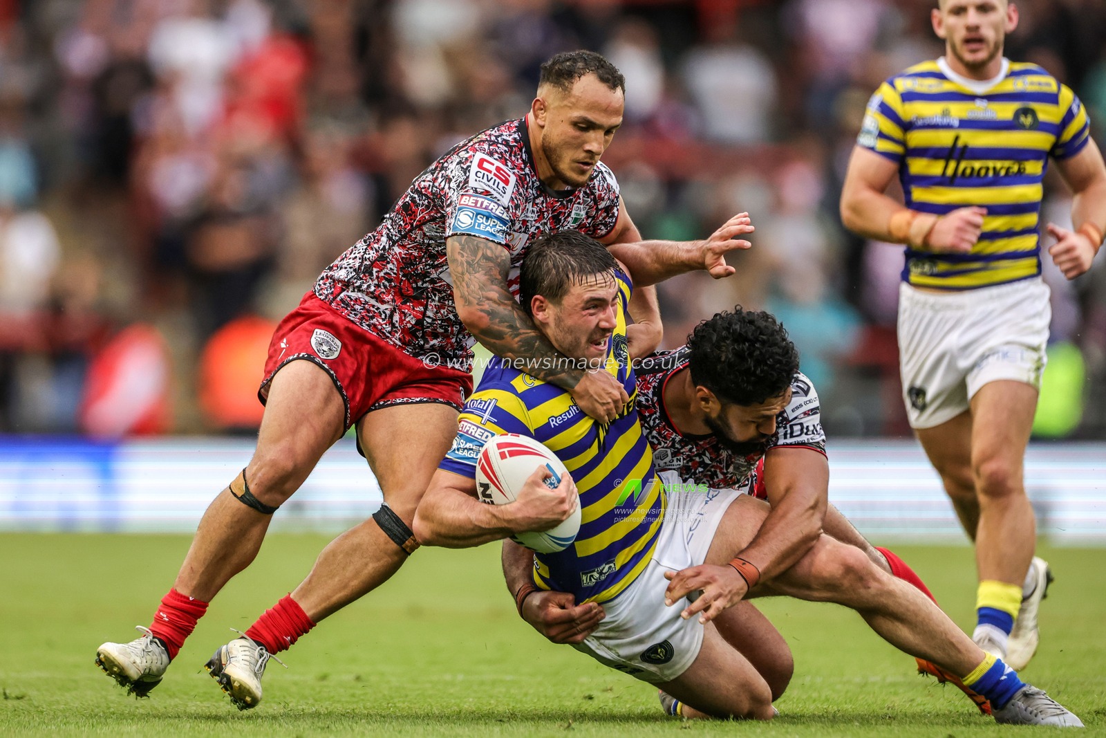 Adam Holroyd of Warrington Wolves is tackled by Liam Horne of Leigh Leopards and Isaac Liu of Leigh Leopards during the Betfred Super League round 20 match Leigh Leopards vs Warrington Wolves at Leigh Sports Village, Leigh, United Kingdom on 25 July 2026

(Photo by Alfie Cosgrove/News Images)