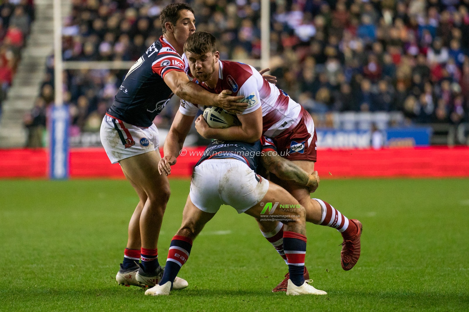 Wigan Warriors's Joe Greenwood is tackled by Sydney Roosters Jake Friend (C)


17th February  2019 , DW Stadium, Wigan, England;  Betfred World Club Challenge, Wigan Warriors vs Sydney Roosters ; 

Credit: Terry Donnelly/News Images