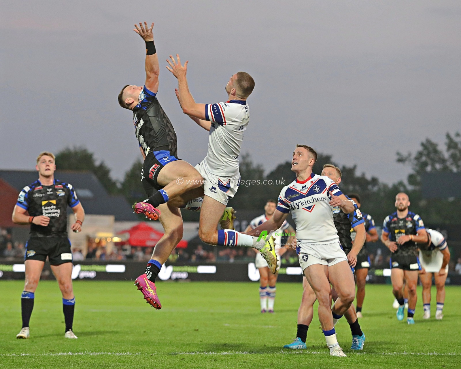 Harry Newman of Leeds Rhinos battles with Max Jowitt of Wakefield Trinity for a high ball during the Betfred Super League round 20 match Wakefield Trinity vs Leeds Rhinos at DIY Kitchens Stadium, Wakefield, United Kingdom, 24th July 2025(Photo by Sam Eaden/News Images)