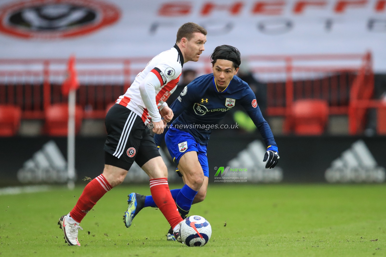 John Fleck #4 of Sheffield United with the ball as Takumi Minamino #19 of Southampton tracks him