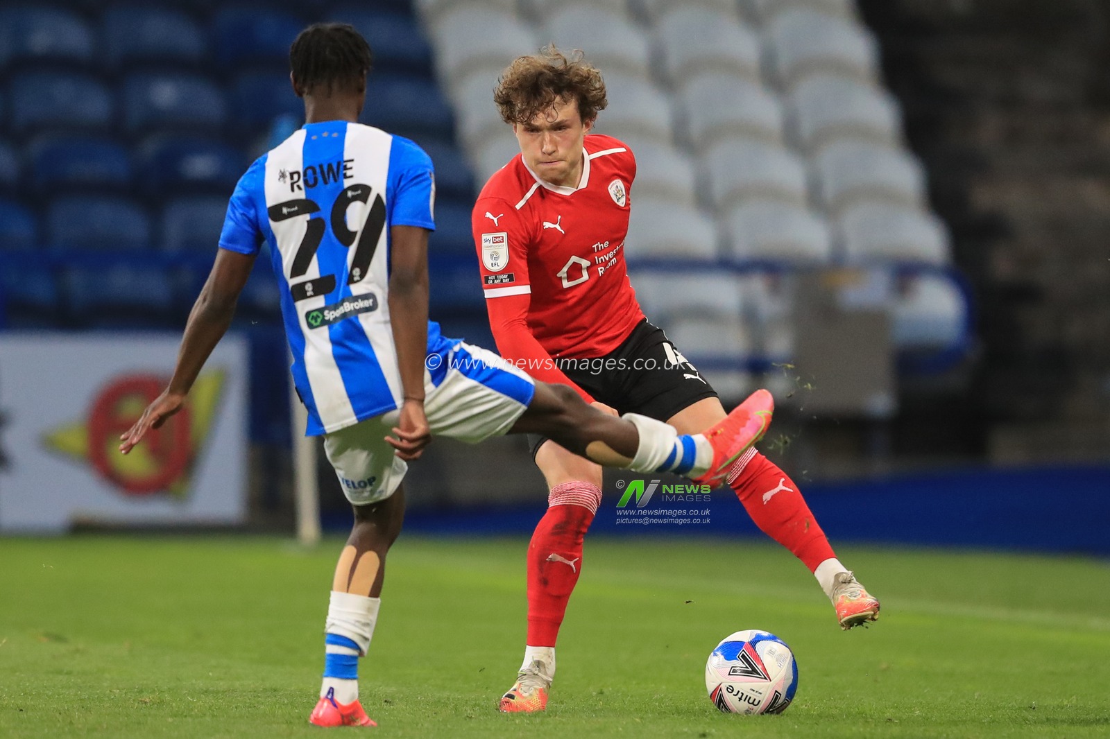 Callum Styles #4 of Barnsley holds the ball as Aaron Rowe #29 of Huddersfield Town pressures