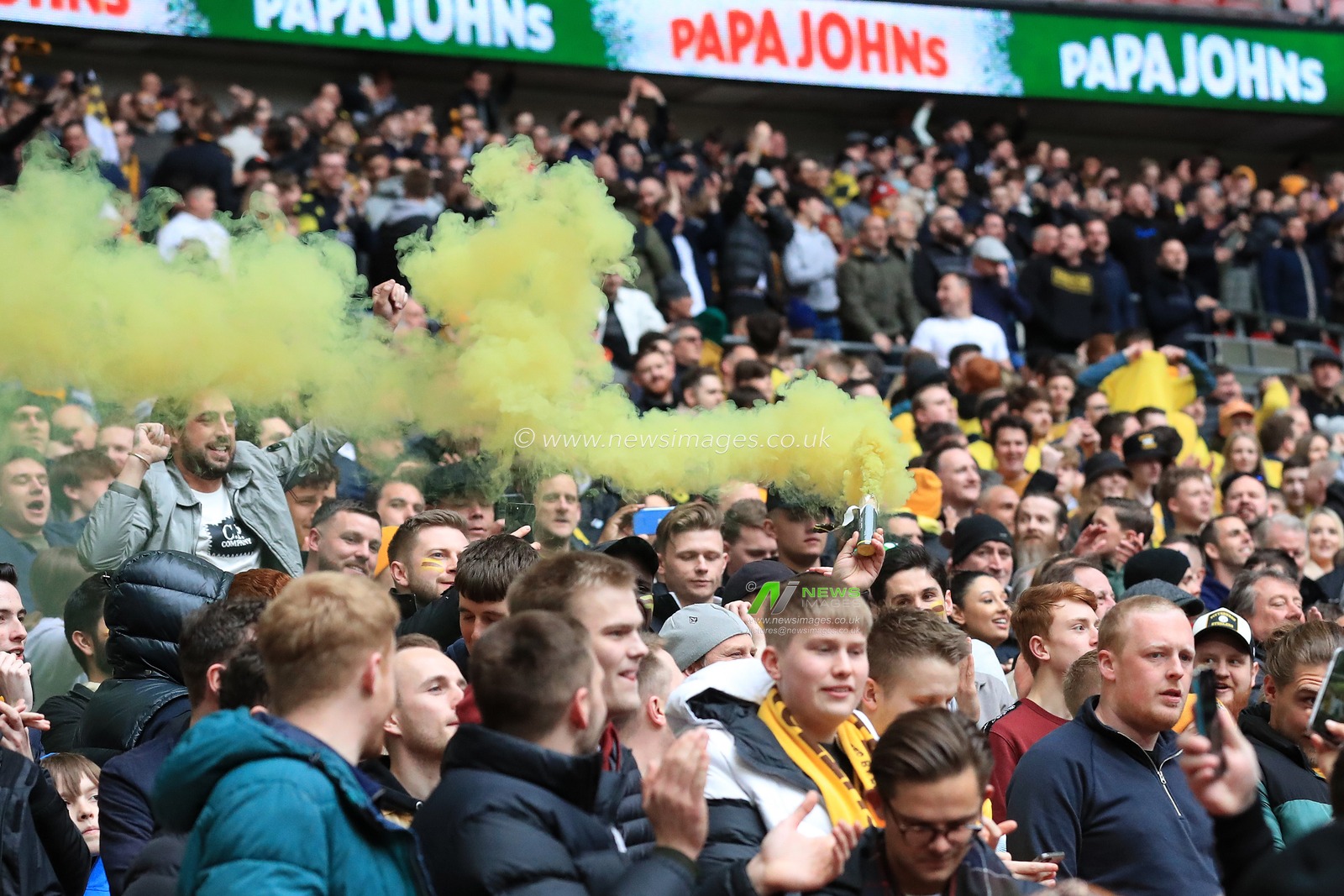 Sutton United fans break out the flare after their team score the first goal.