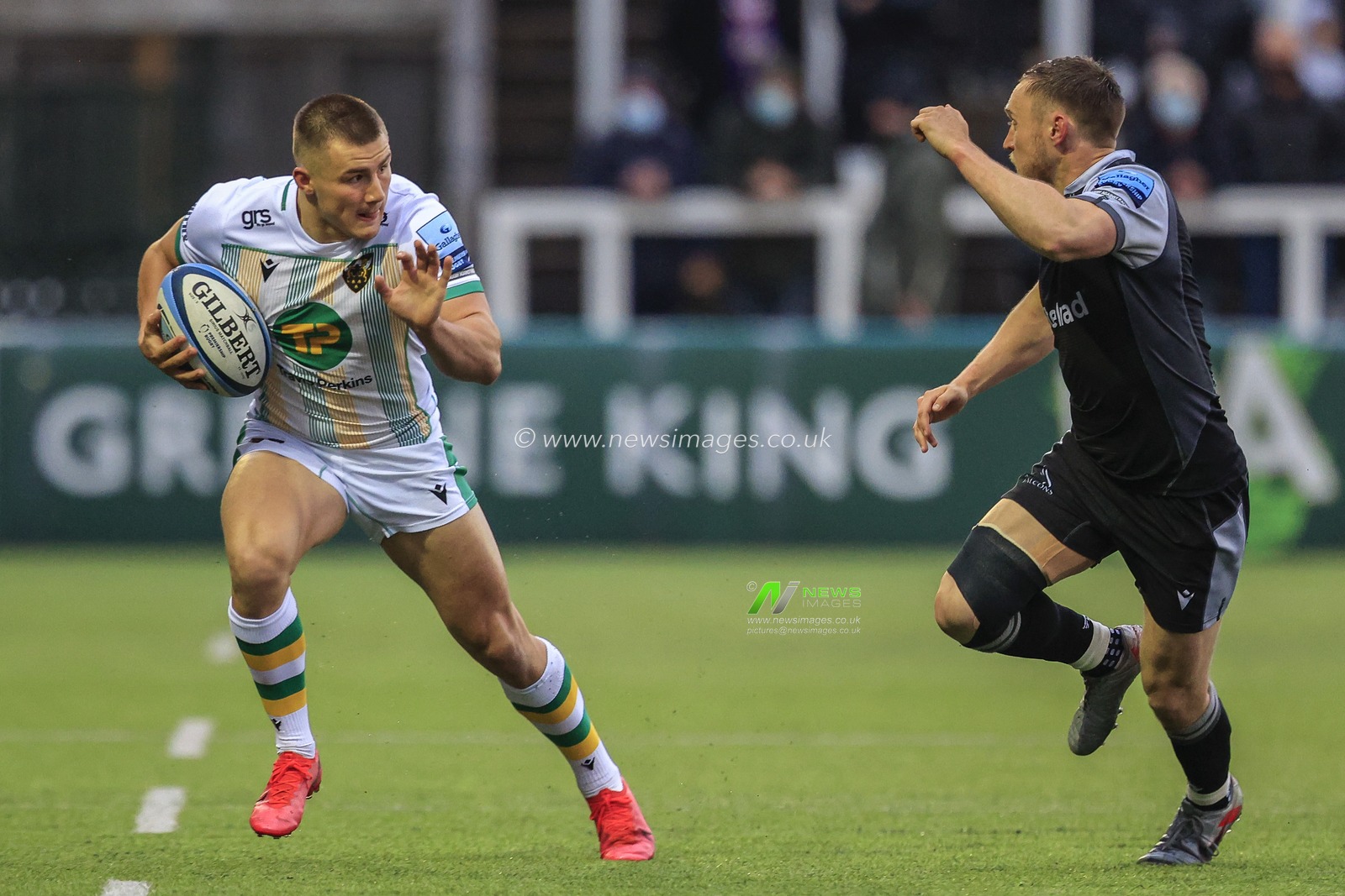 Ollie Sleightholme of Northampton Saints in possession of the ball as Brett Connon of Newcastle Falcons gives chase