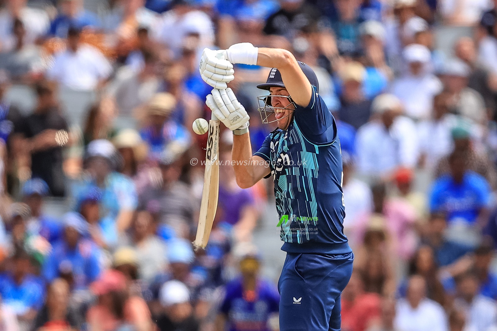 The ball rolls up the bat of Craig Overton of England as he strikes it