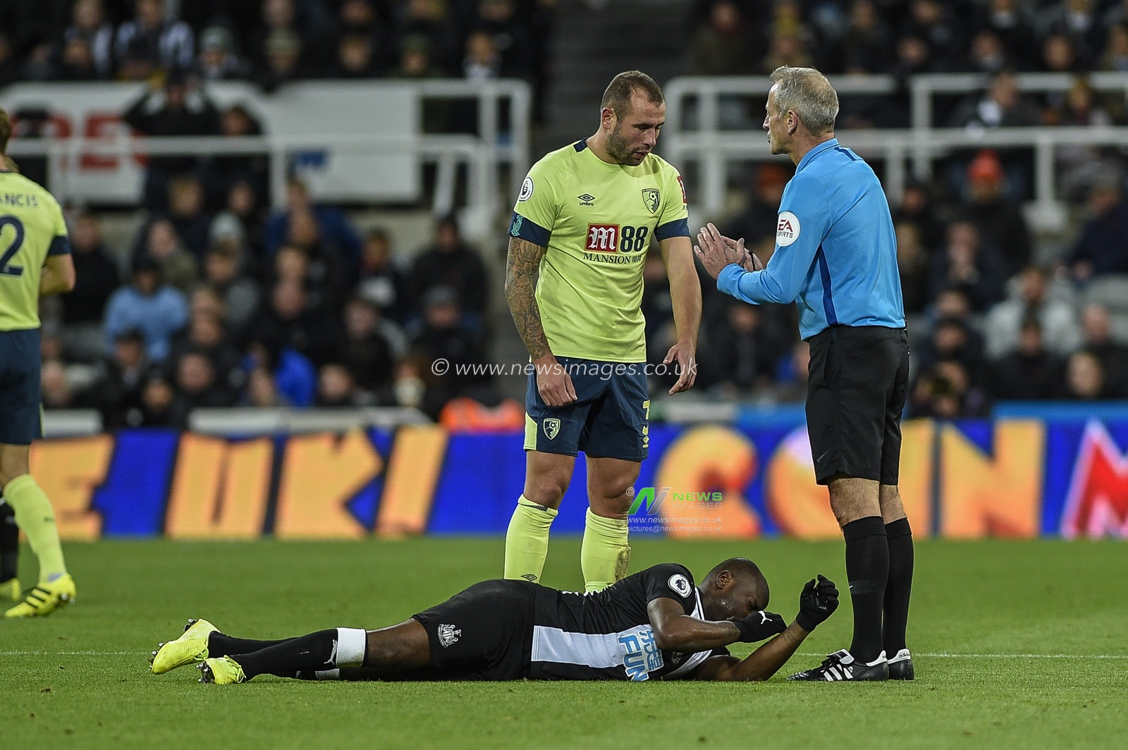 9th November 2019, St. James's Park, Newcastle, England; Premier League, Newcastle United v Bournemouth : Jetro Willems (15) of Newcastle United lies injured next to referee Martin Atkinson and Steve Cook (3) of Bournemouth

Credit: Iam Burn/News Images