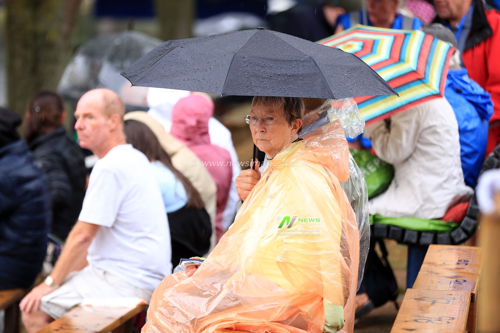 Members of the crowd dress ready for rain.
