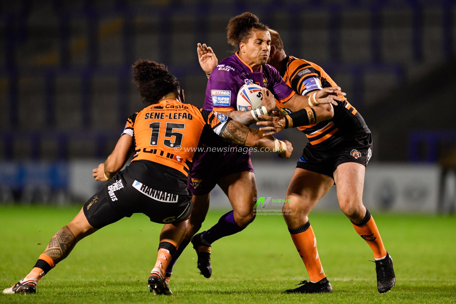 Ashton Golding (1) of Huddersfield Giants is tackled by Jesse Sene-Lefao (15) and Liam Watts (8) of Castleford Tigers