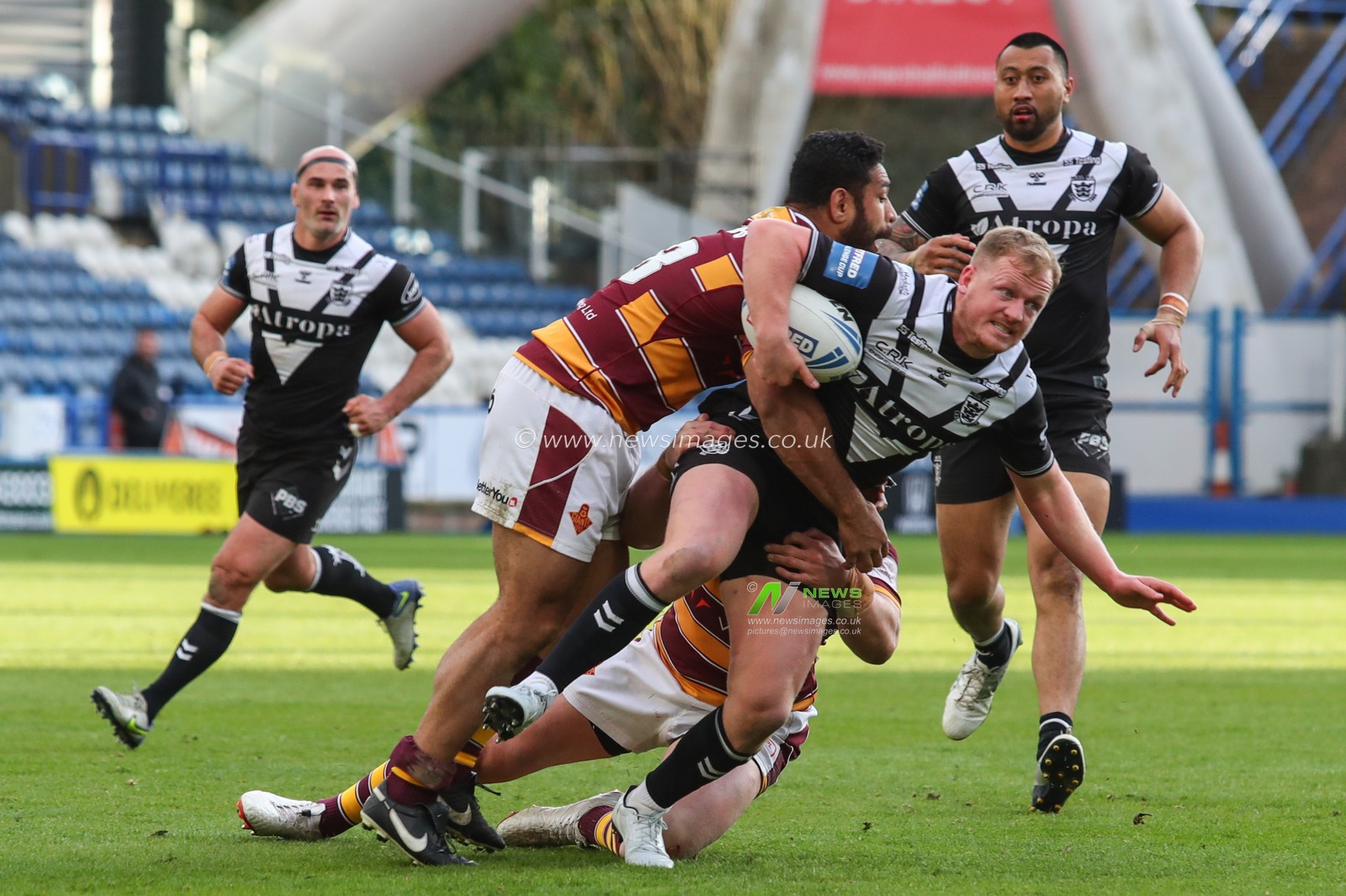 Jordan Johnstone #21 of Hull FC is tackled by the Huddersfield defence
