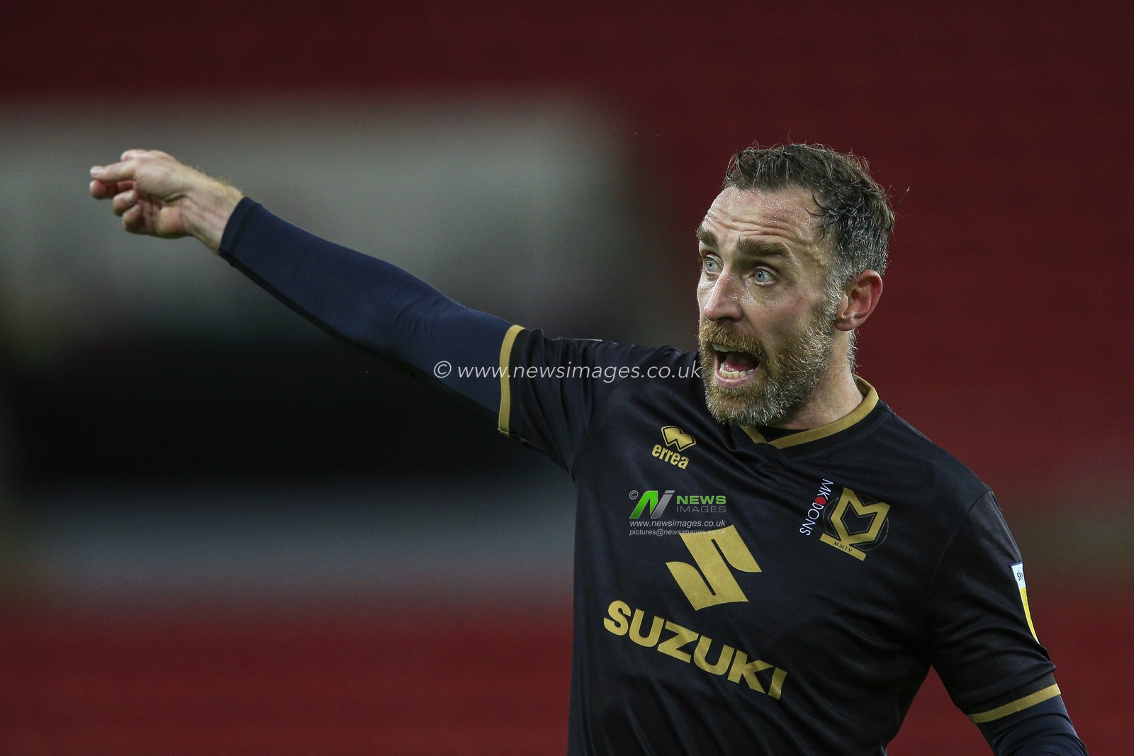 Richard Keogh #4 of Milton Keynes Dons discusses a previous decision with the referee's assistant