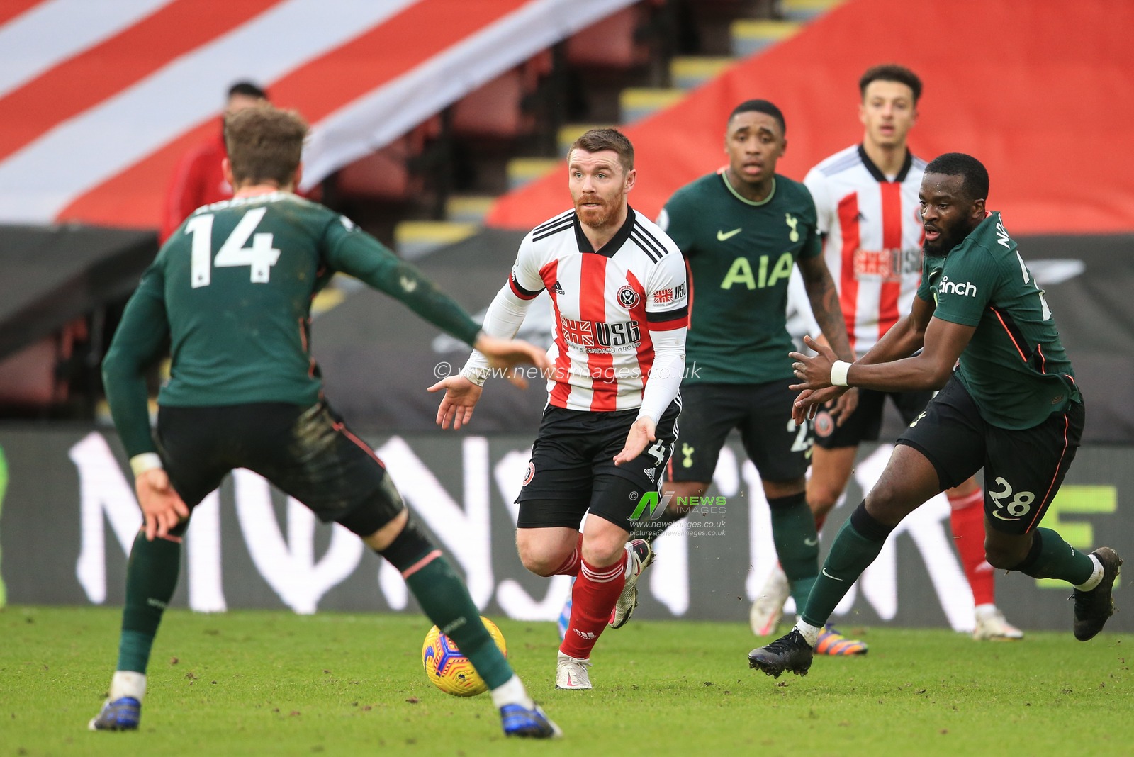 John Fleck #4 of Sheffield United breaks wit the ball and looks for pass as Joe Rodon #14 of Tottenham Hotspur pressures