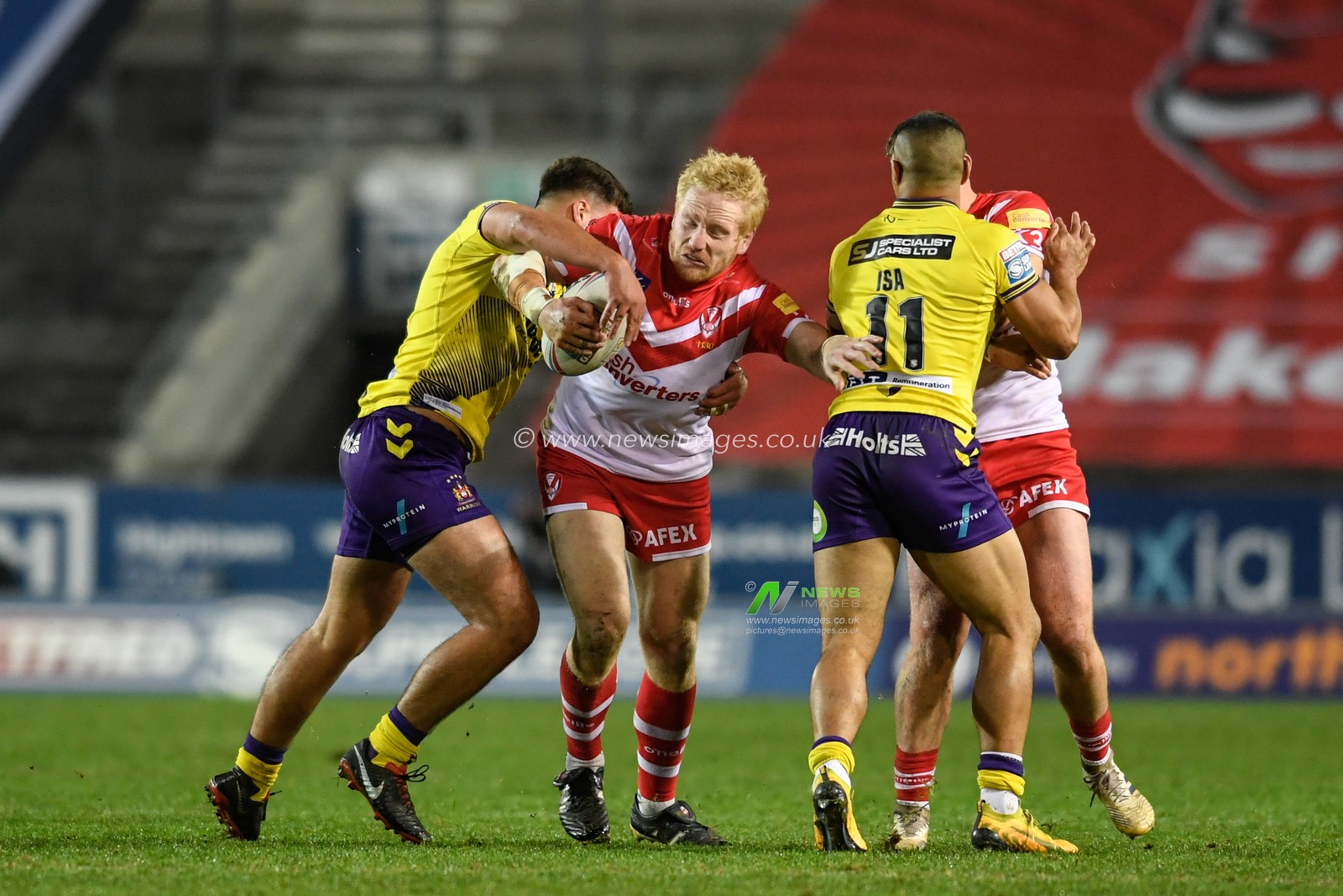 James Graham (32) of St Helens is tackled by Oliver Partington (17) of Wigan Warriors