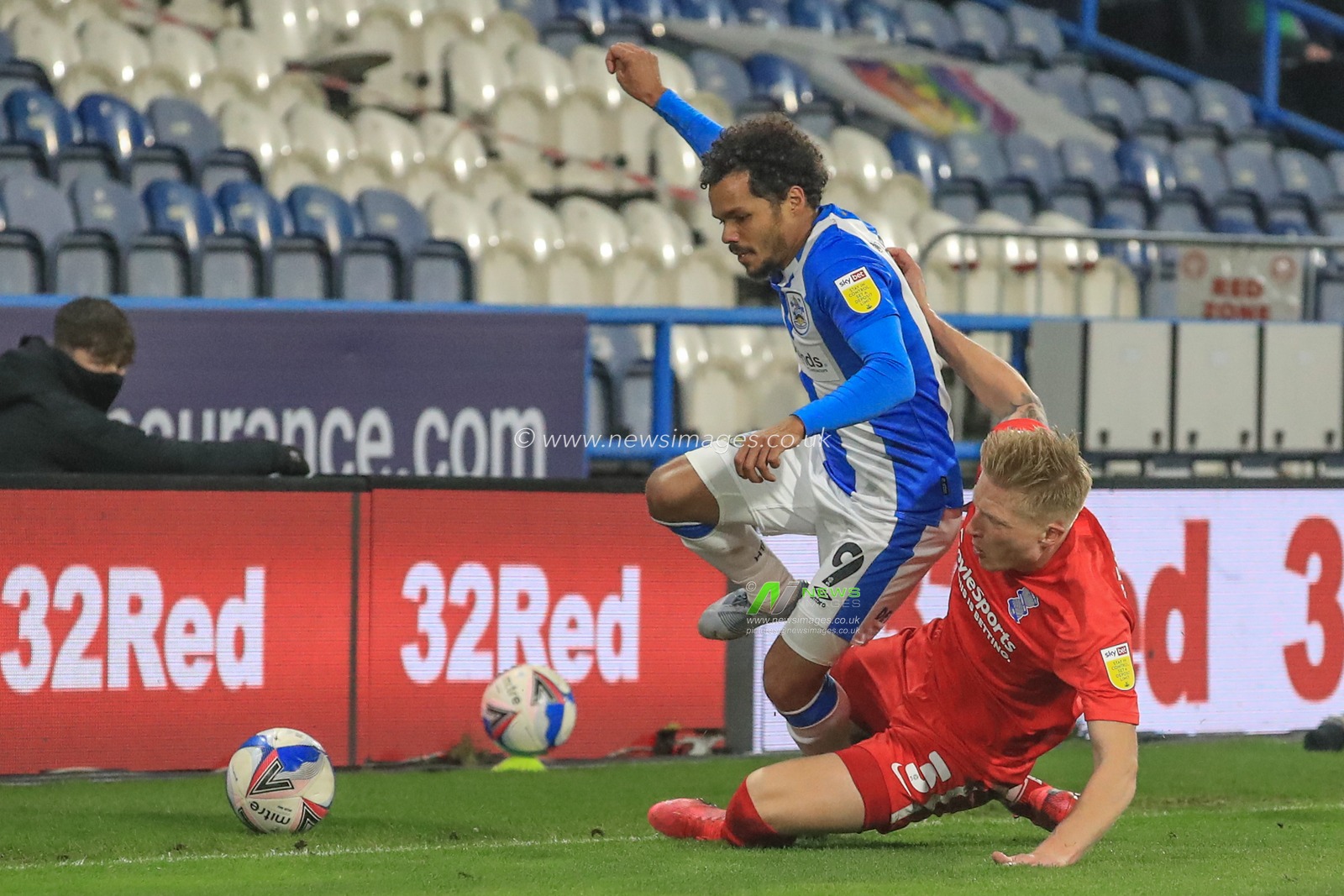 Kristian Pedersen #3 of Birmingham City slides into Duane Holmes #9 of Huddersfield Town to put the ball out of play