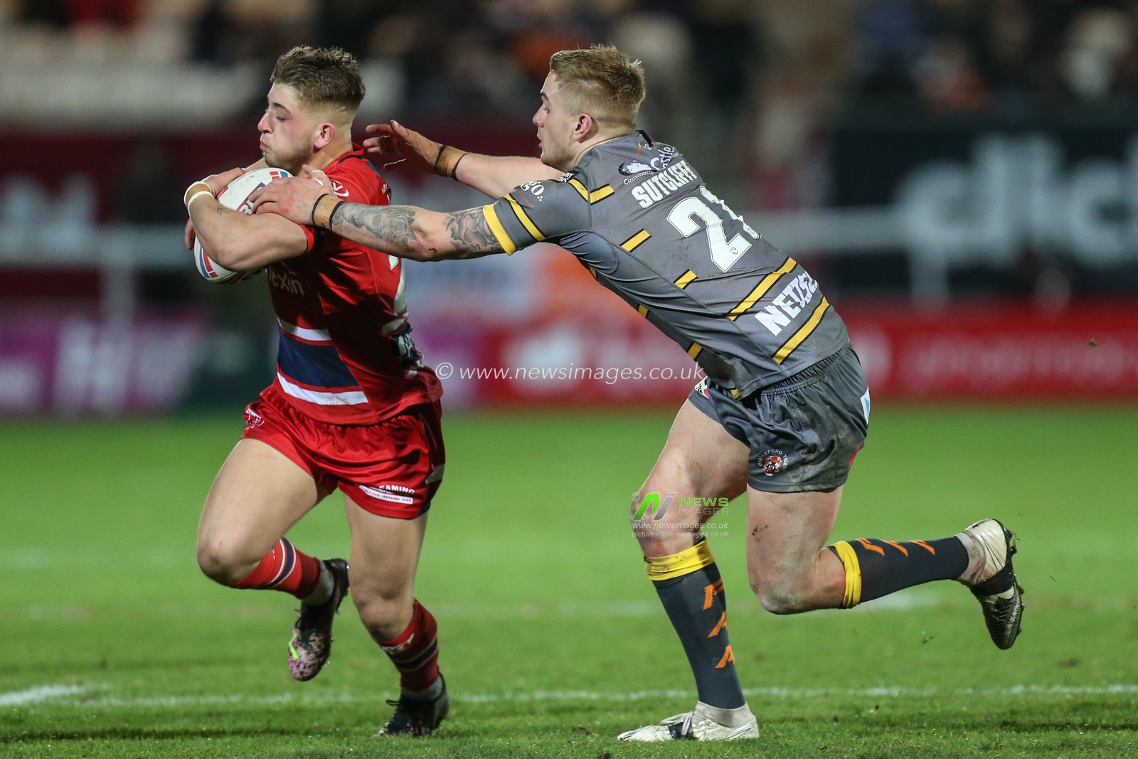 Mikey Lewis #20 of Hull KR avoids being tackled by Alex Sutcliffe #21 of Castleford Tigers