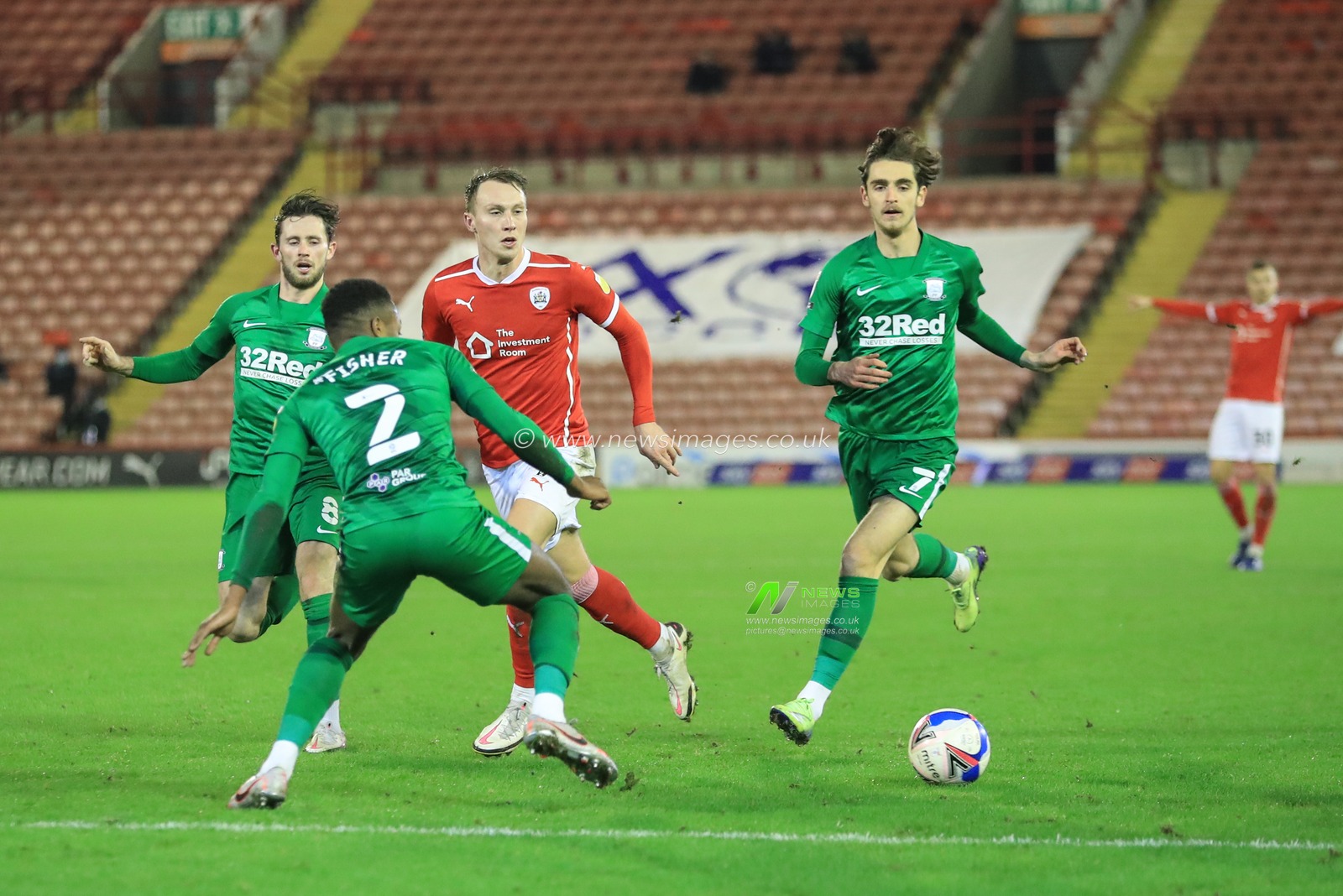 Cauley Woodrow #9 of Barnsley slips the ball past Darnell Fisher #2 of Preston North End for Victor Adeboyejo #29 of Barnsley to score