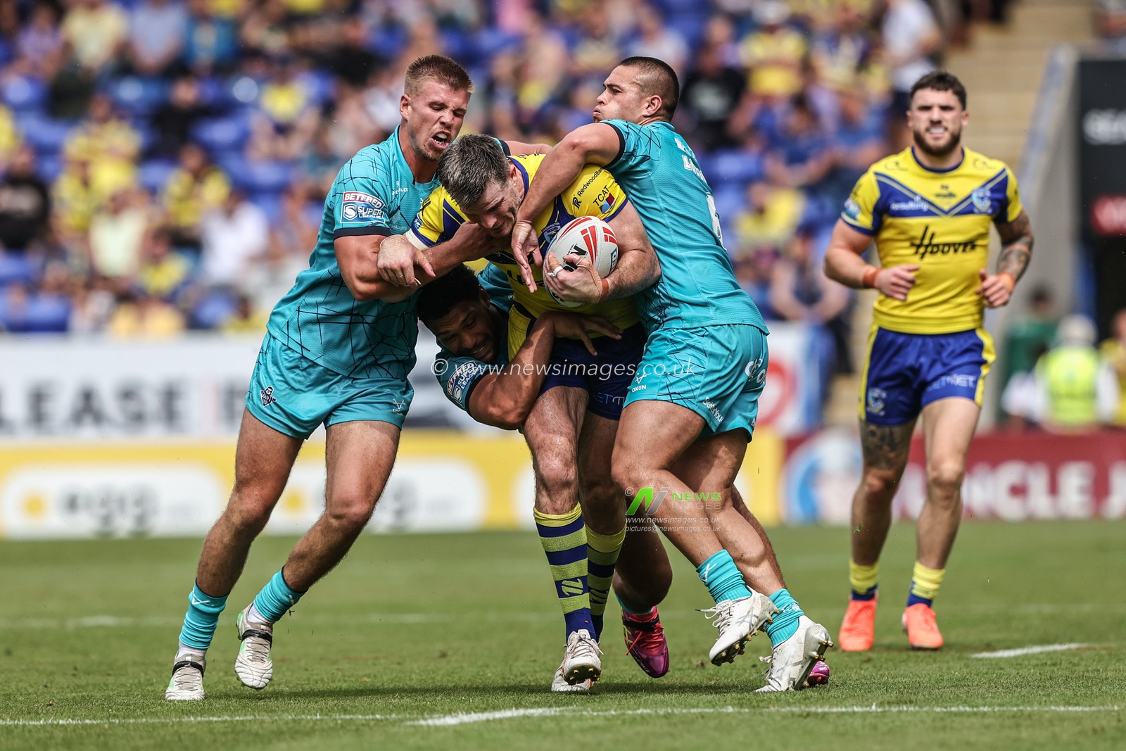 Lachlan Fitzgibbon of Warrington Wolves is tackled by Tui Lolohea of Huddersfield Giants and Harry Rushton of Huddersfield Giants during the Betfred Super League round 15 match Warrington Wolves vs Huddersfield Giants at Halliwell Jones Stadium, Warrington, United Kingdom, 21st June 2025

(Photo by Alfie Cosgrove/News Images)