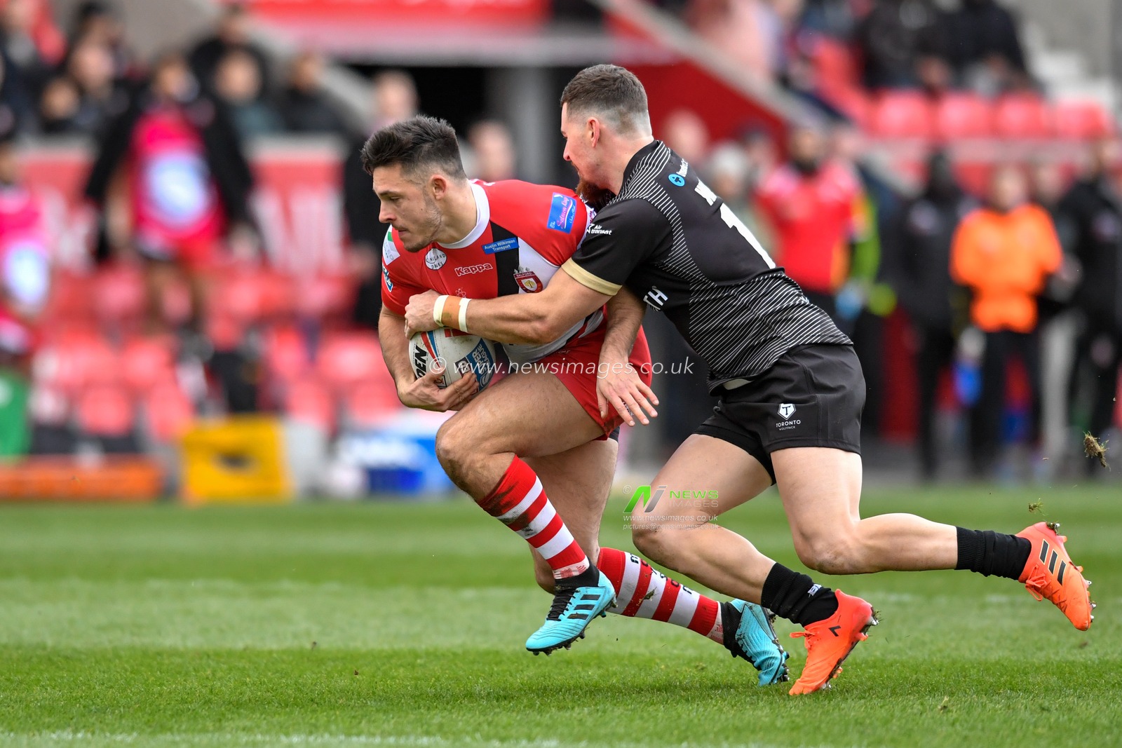 8th February 2020, AJ Bell Stadium, Eccles, England; Betfred Super League, Salford Red Devils v Toronto Wolfpack : Niall Evalds (1) of Salford Red Devils is tackled by Blake Wallace (17) of Toronto Wolfpack