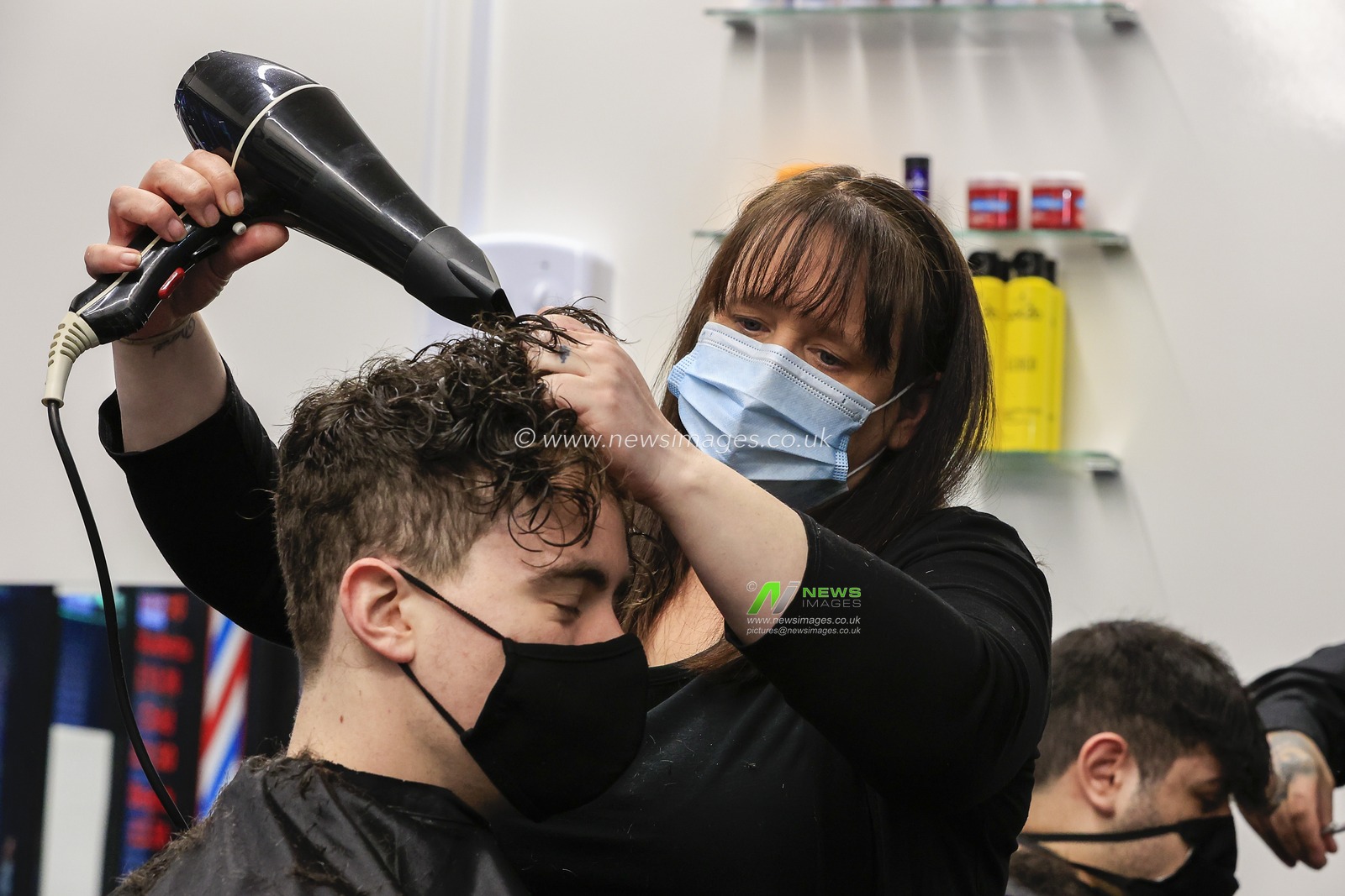 Emma cuts a customer's hair at Henry's Barbershop, High Bridge, Newcastle upon Tyne, as national lockdown restrictions are eased in England