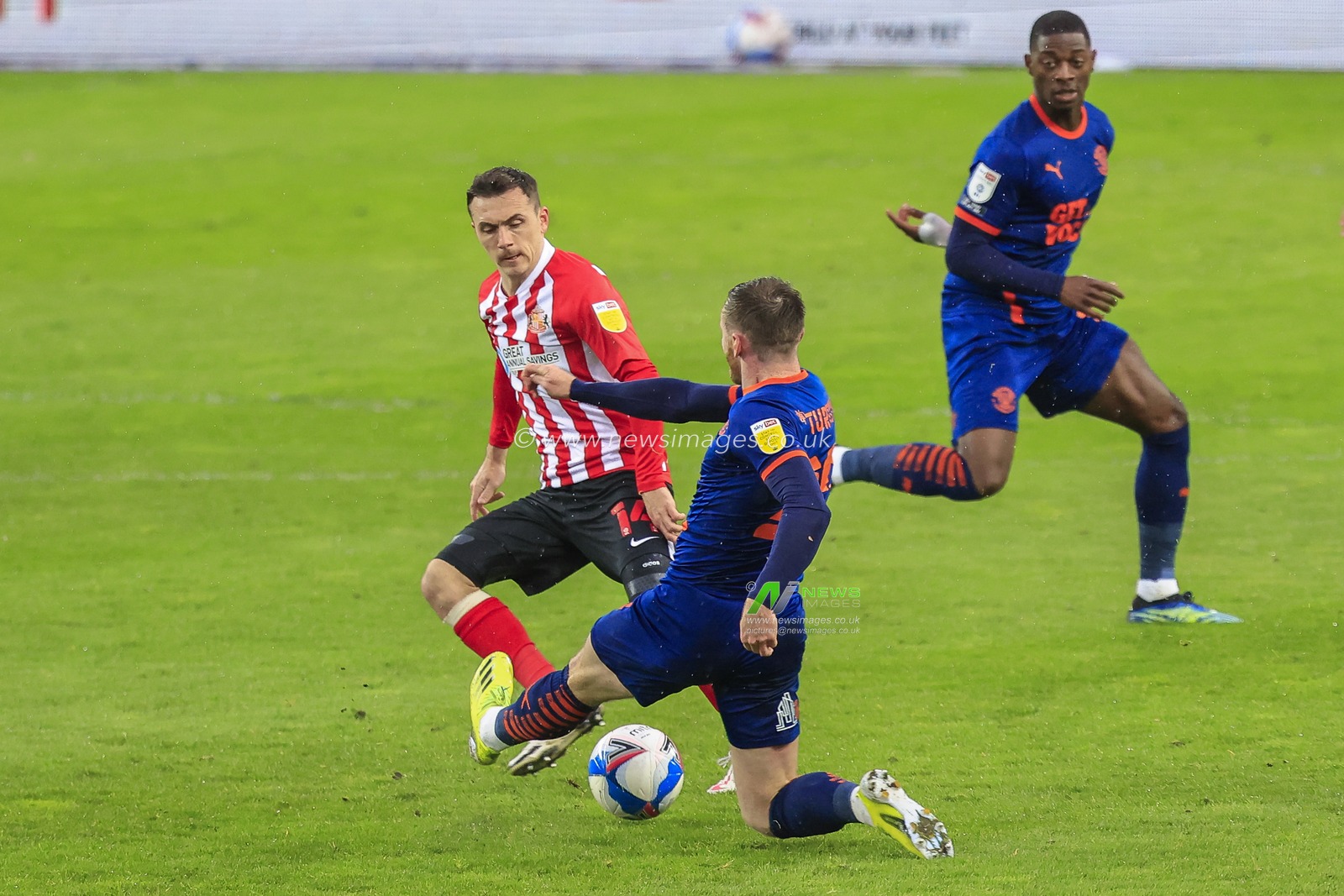 Oliver Turton #20 of Blackpool tries to block a pass from Josh Scowen #14 of Sunderland