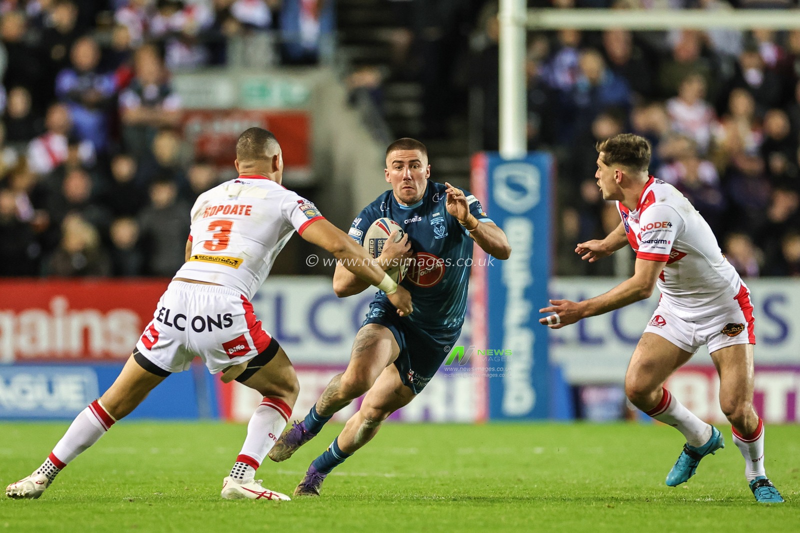 Greg Minikin #21 of Warrington Wolves looks for a way past Will Hopoate #3 of St Helens and Lewis Dodd #7 of St Helens during the Betfred Super League Round 10 match St Helens vs Warrington Wolves at Totally Wicked Stadium, St Helens, United Kingdom, 20th April 2023

(Photo by Mark Cosgrove/News Images)