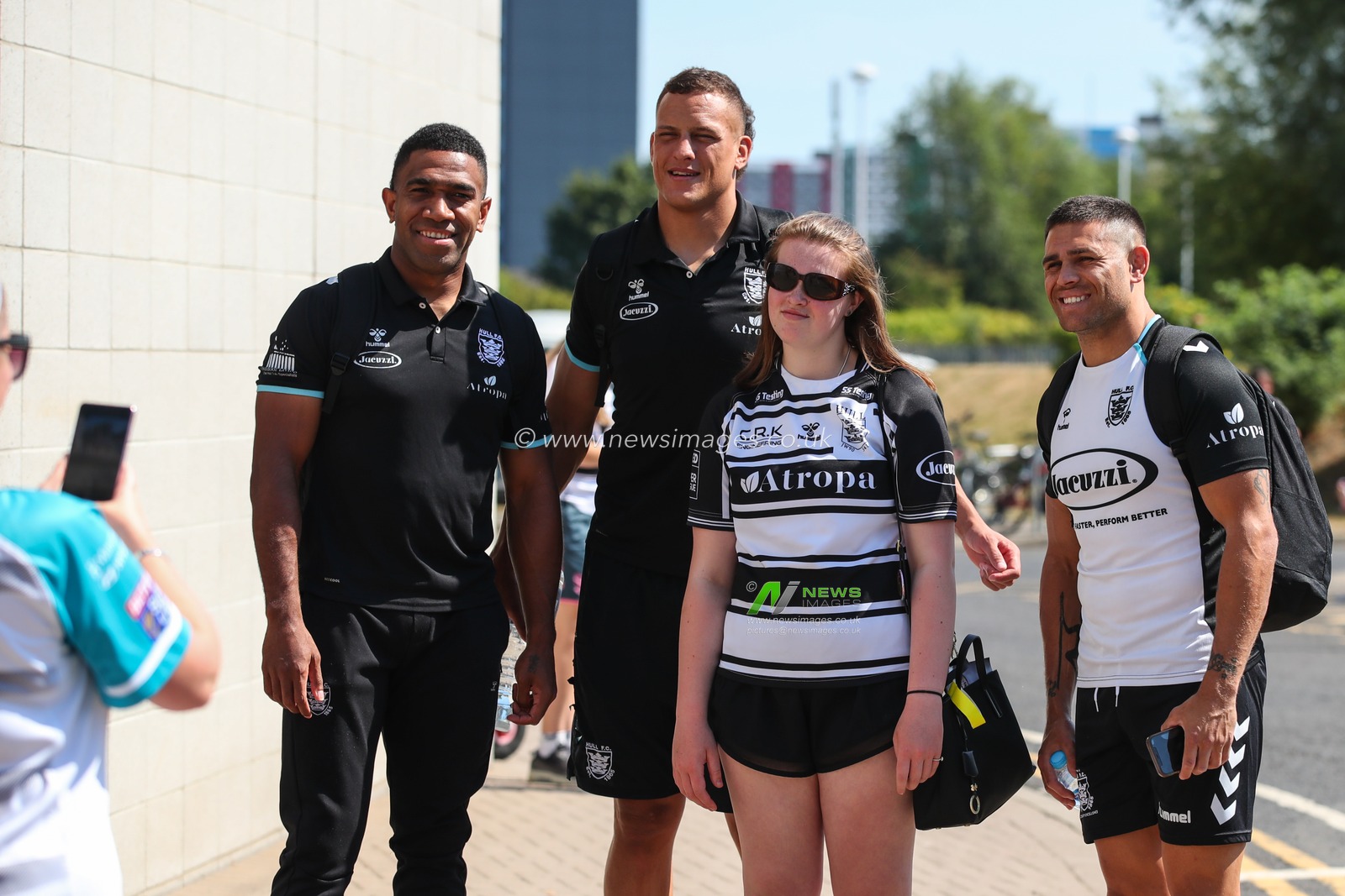Mitieli Vulikijapani #25 Kane Evans #16 and Will Smith #40 of Hull FC have a photo taken with a fan