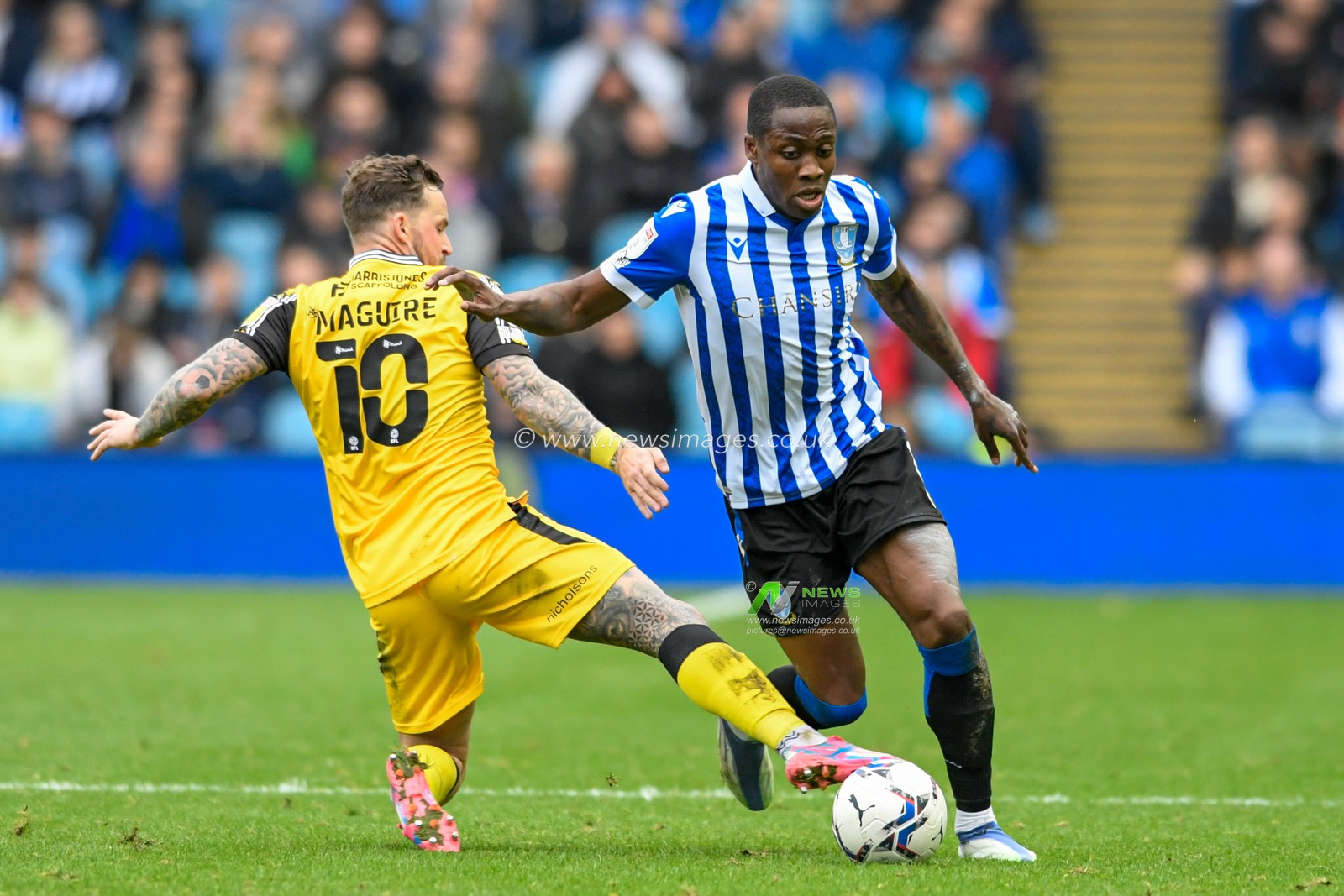 Dennis Adeniran #8 of Sheffield Wednesday looks for a way past Chris Maguire #10 of Lincoln City