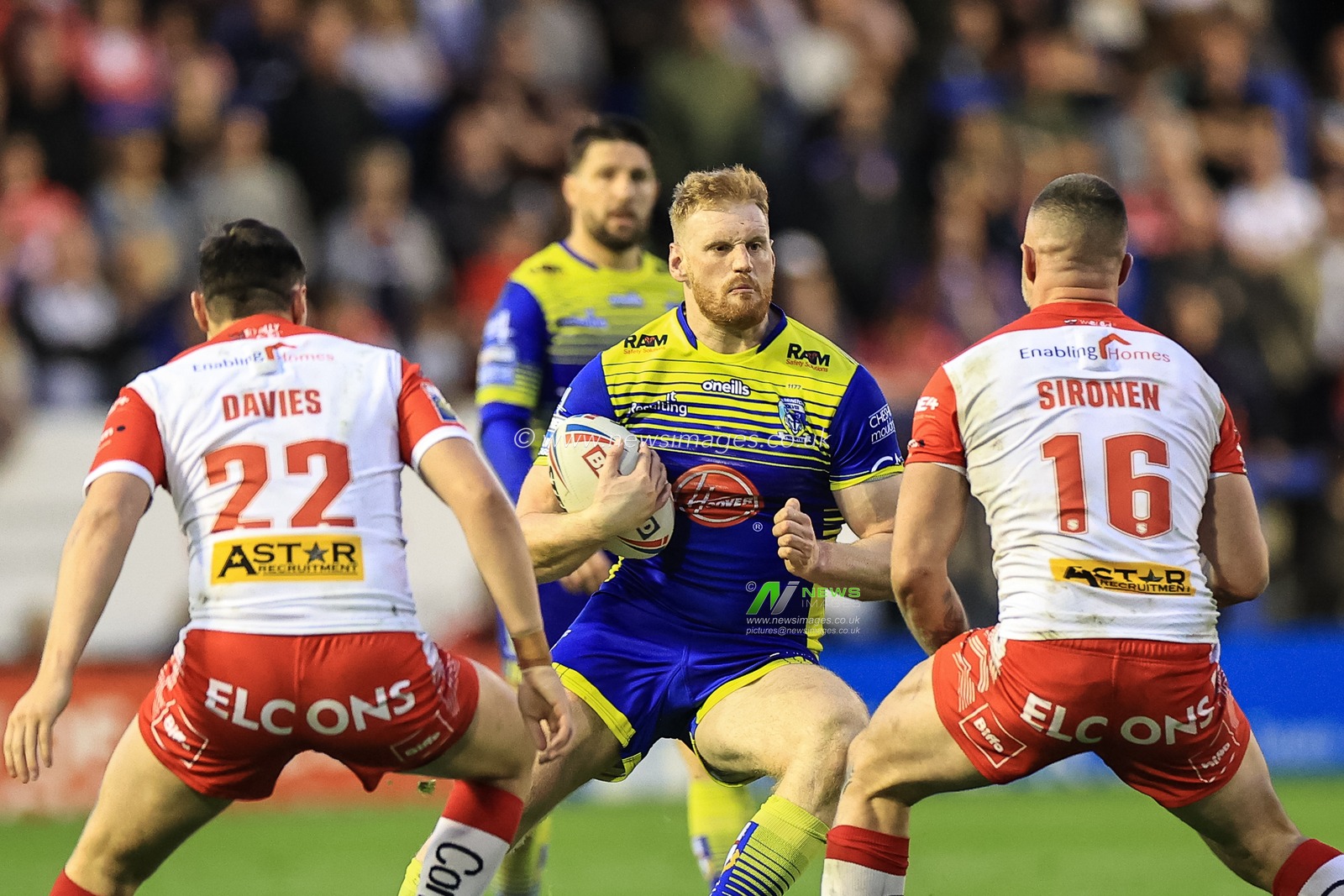 Joe Bullock #15 of Warrington Wolves looks for a way through Ben Davies #22 of St Helens and Curtis Sironen #16 of St Helens