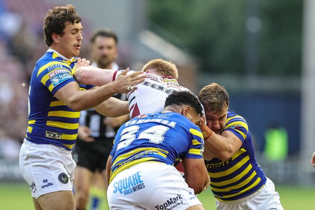 Zach Eckersley of Wigan Warriors is tackled by Max Wood of Warrington Wolves Kelepi Tanginoa of Warrington Wolves and Leon Hayes of Warrington Wolves during the Betfred Super League round 18 match Wigan Warriors vs Warrington Wolves at The Brick Community Stadium, Wigan, United Kingdom on 10 July 2026

(Photo by Mark Cosgrove/News Images)
